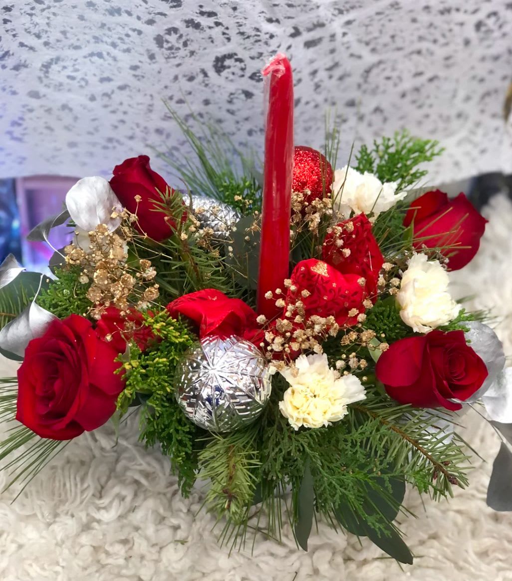 4 roses Christmas centerpiece  - Get your home in the holiday spirit with this holiday centerpiece that will look wonderful on your dining room table or on the mantle over a roaring fire in the fireplace. Red flowers, , white poms, and more give this arrangement a little magical touch. Send to loved ones or use at your next gathering this season. 