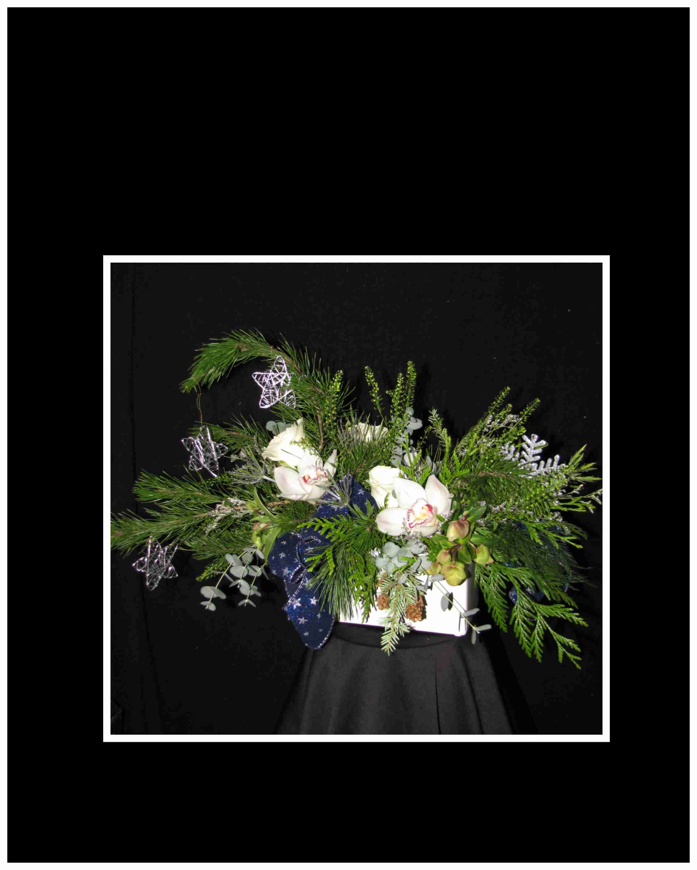 Silent Night Christmas arrangement - A classic arrangement with a mix of greens and orchids with Christmas decorations mixed throughout silver and blue in a ceramic container  Approximately 10 H&quot; X 18&quot; Wide