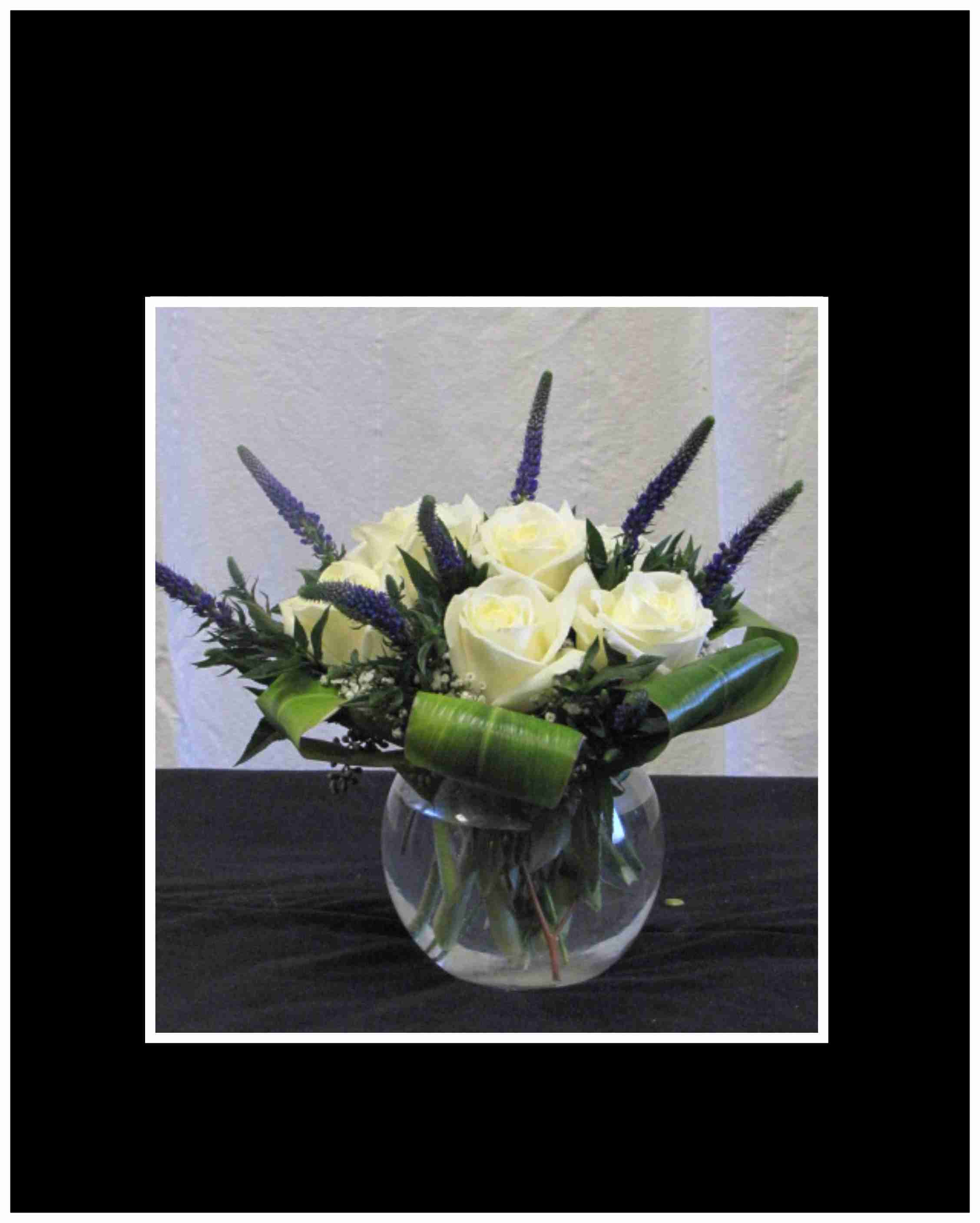 New Beginnings Bouquet - he New Beginnings bouquet is arranged in a clear glass bubble bowel using white roses and Veronica with curled cordyline leaves, to create a bouquet that will show how much you care.  Approximately 10"H x 10"W.