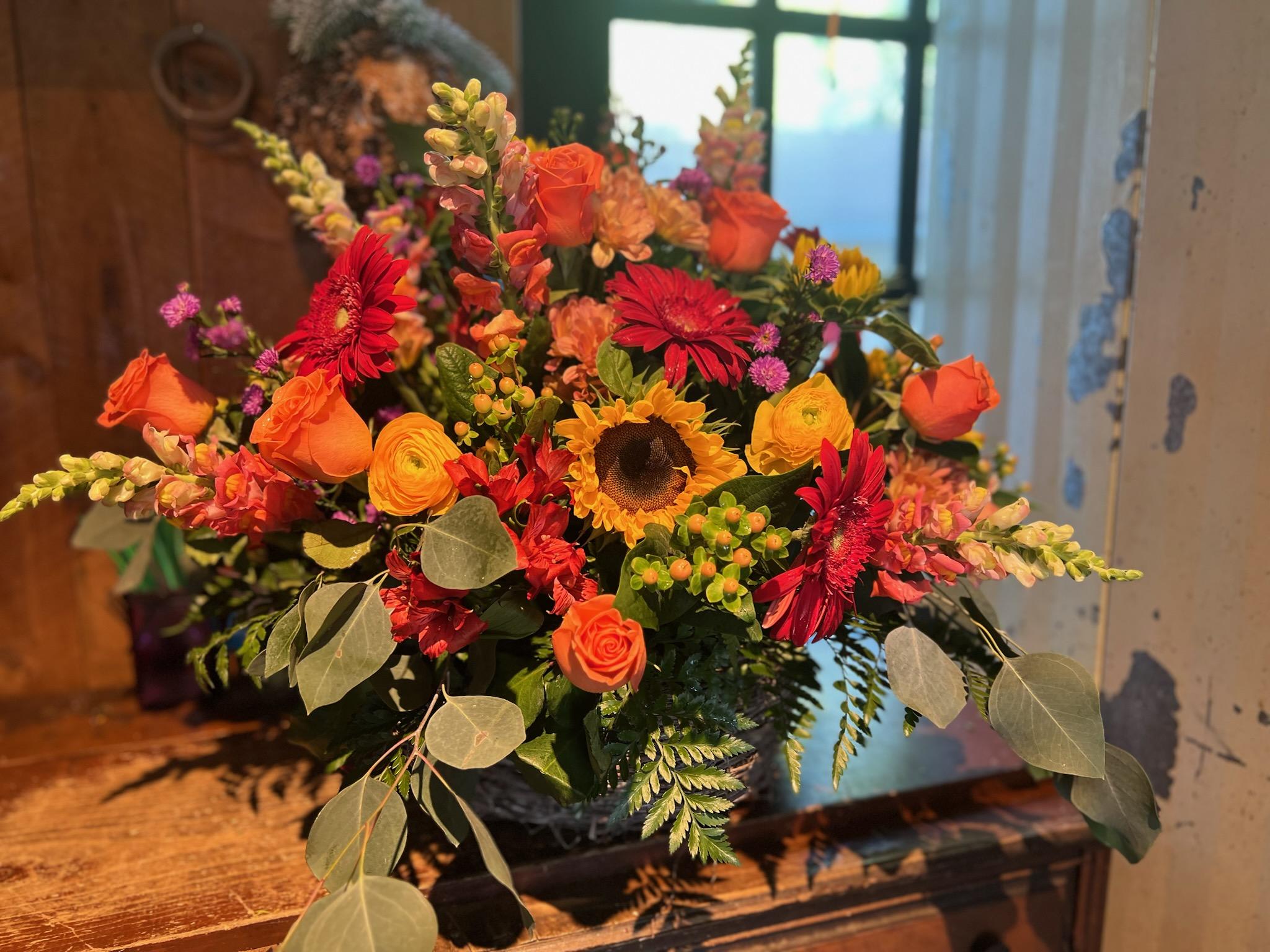 Colors of Fall Basket Arrangement - All the beautiful colors of fall flowers designed in a wicker basket. Perfect for any occasion of the season.