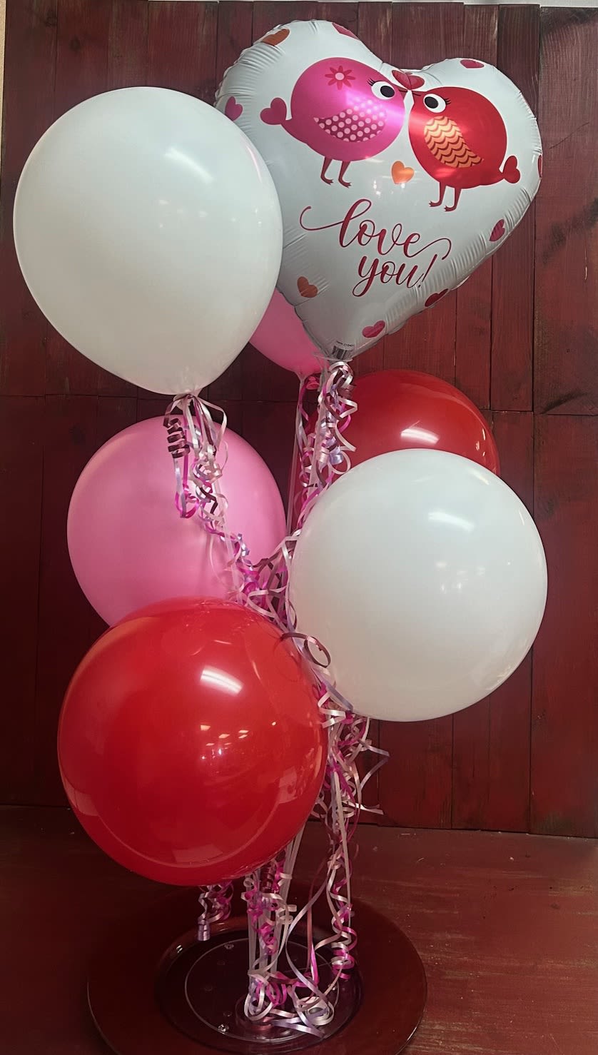 I Love You Balloon Tower - 6 latex balloons and 1 mylar balloon arranged on a plastic stand with balloon ribbons. Colors will be in the red, white and pink family. 