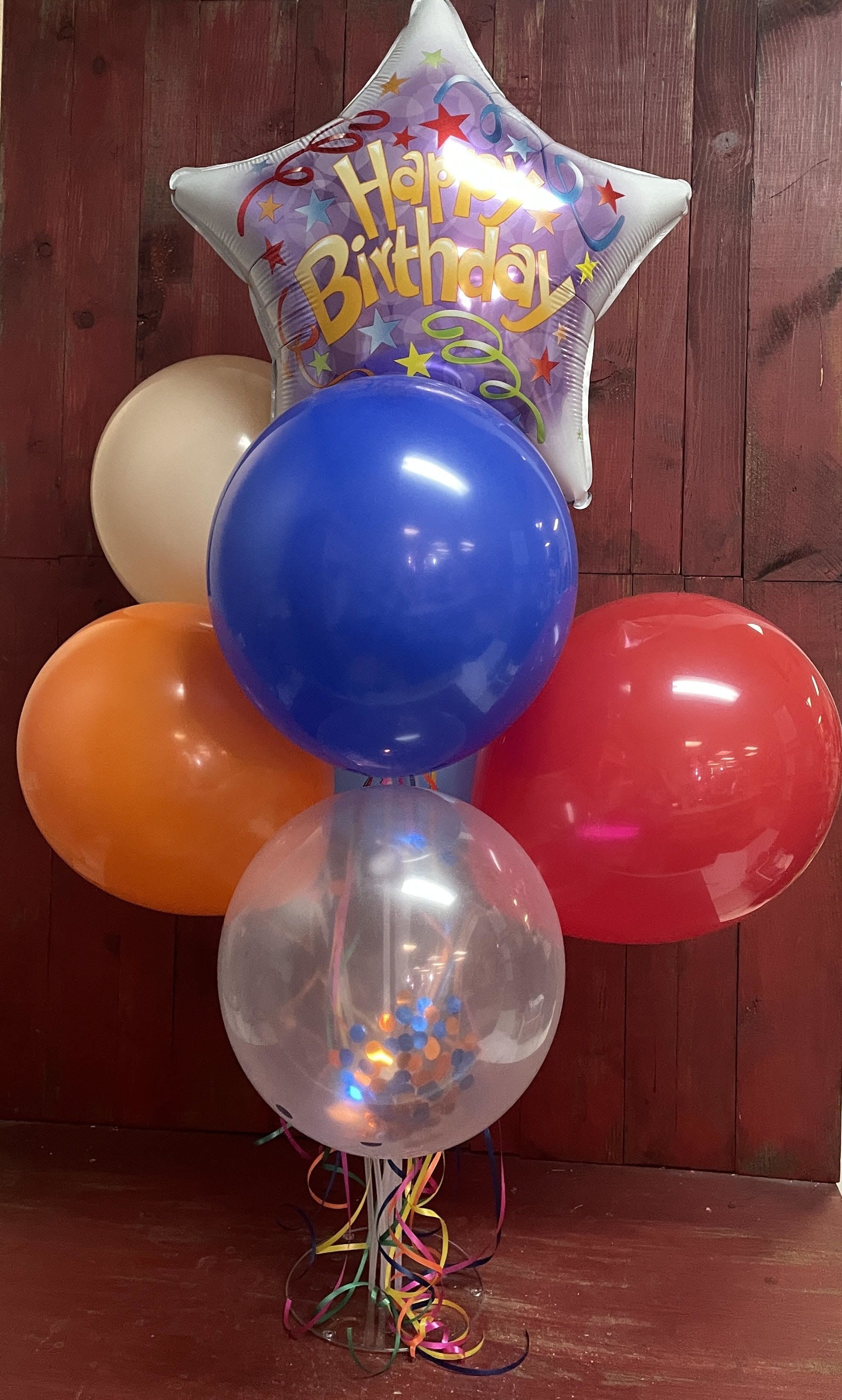 Happy Birthday Balloon Tower (Orange, Blue, Red) - 6 latex balloons and 1 mylar balloon arranged on a plastic stand with balloon ribbons. Happy, happy birthday! 