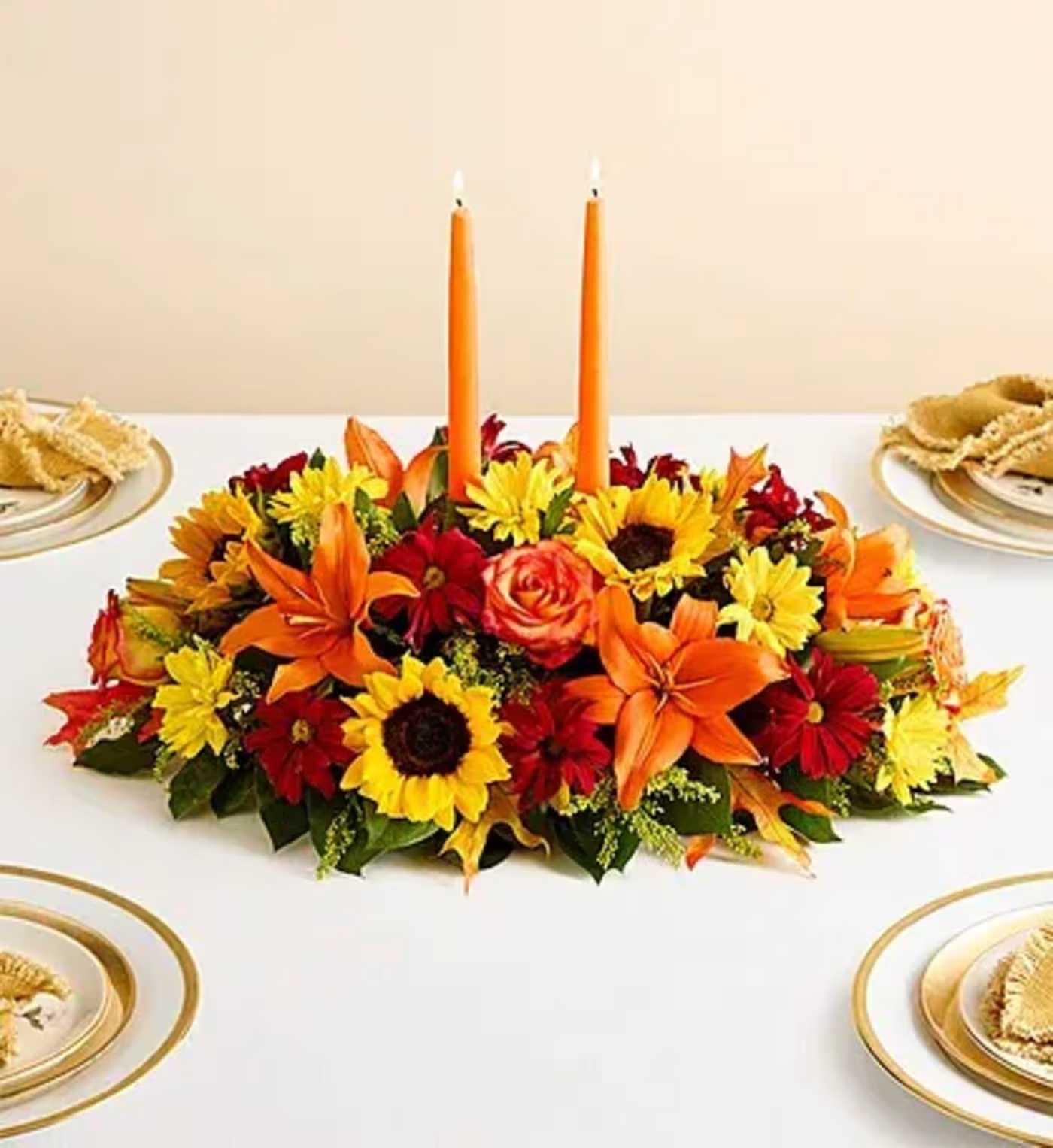 Thankful Givings  - our best-selling fall centerpiece. Crafted by our artisan florists, it’s filled with a gathering of fresh-picked blooms in brilliant colors and finished with an orange candle to warm hearts and homes Perfect for you or your loved one's Thanksgiving Table 
