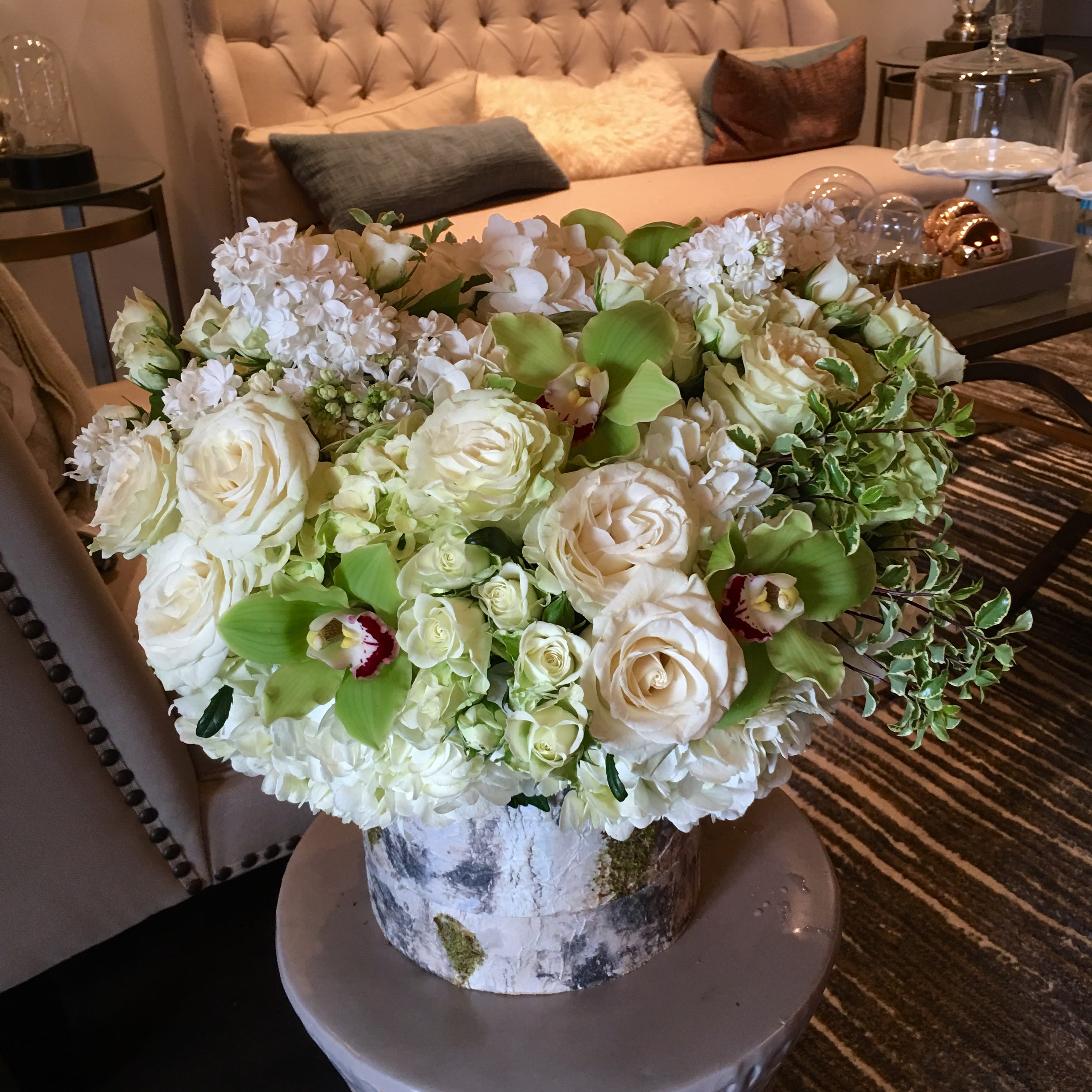 Eva - A lush pave full of hydrangea and roses, with accents of cymbidums and fragrant lilac in a medium birch covered vase.