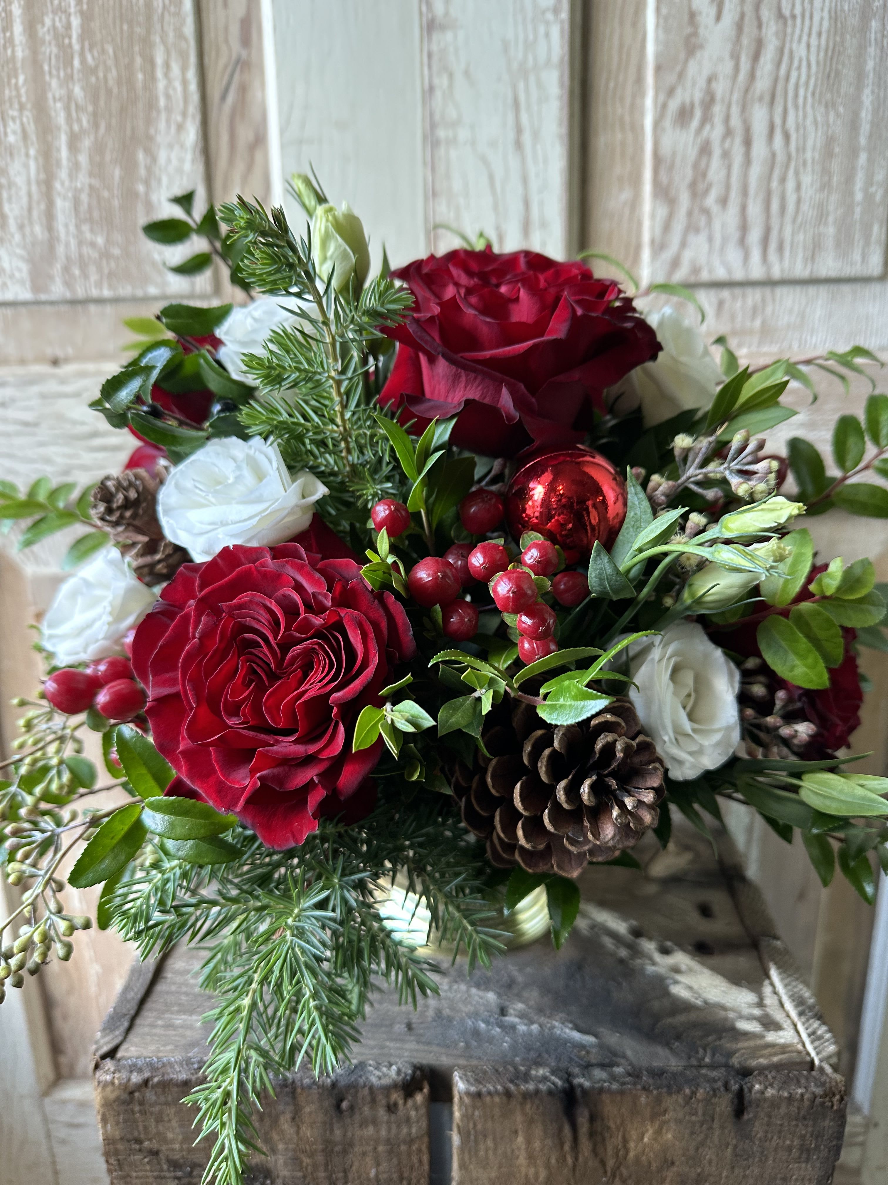 I’ll be home for Christmas  - A perfect table centerpiece filled with roses, lisianthus, red hypericum berries and holiday accents! 