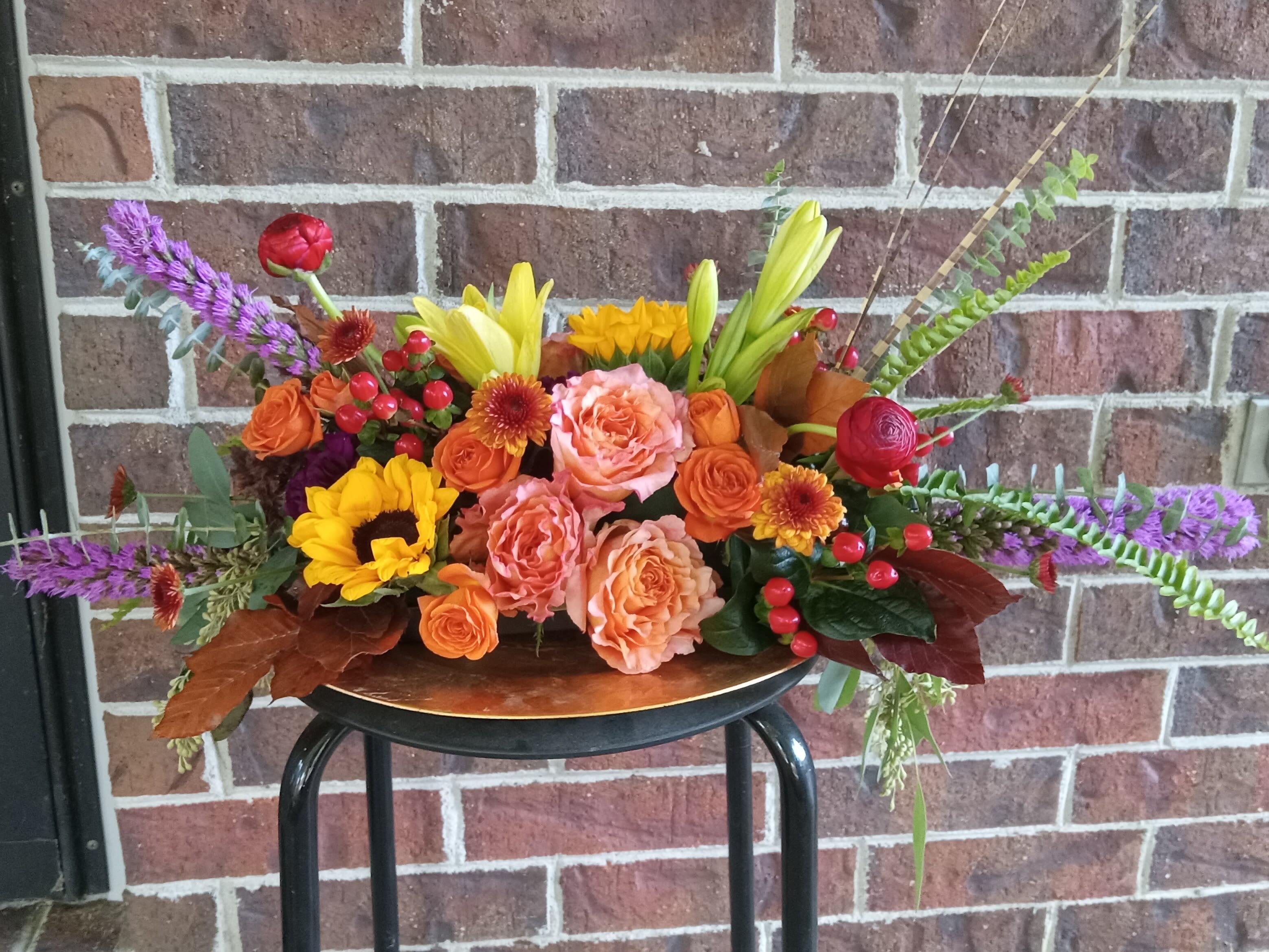 Full Harvest by BloomNation™ - No dinner party or food gathering is complete without a centerpiece and this large arrangement makes a big statement on any table. Featuring gorgeous &quot;Free Spirit&quot; roses, yellow Asiatic lilies, red ranunculus and a variety of other flowers, this arrangement dresses up any event. Send it as a housewarming or thank you gift.   APPROXIMATE DIMENSIONS 25&quot; W X 14&quot; H