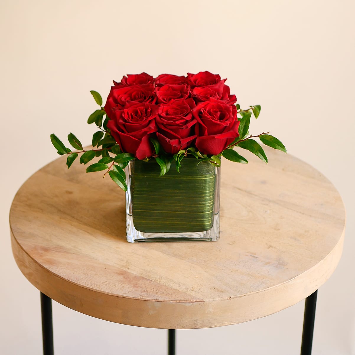 Red Rose Cube - This romantic arrangement features nine elegant red roses adorned with greenery in a 5x5&quot; leaf lined glass cube.