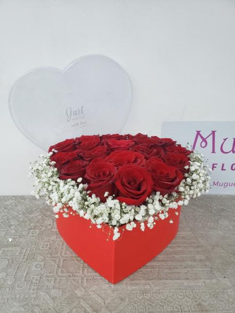 Flames of Love: 24 Red Roses in Heart Shape Red Box Arrangement - Love is a fire that burns passionately, illuminating our lives with warmth and intensity. The &quot;Flames of Love&quot; arrangement brings this sentiment to life with 24 red flame roses arranged in a heart shape within a red box. Join us as we explore the petals of this arrangement, where each rose represents a flicker of the flame that ignites the heart.  Box Colors available: Red, Black, White  Item: #208