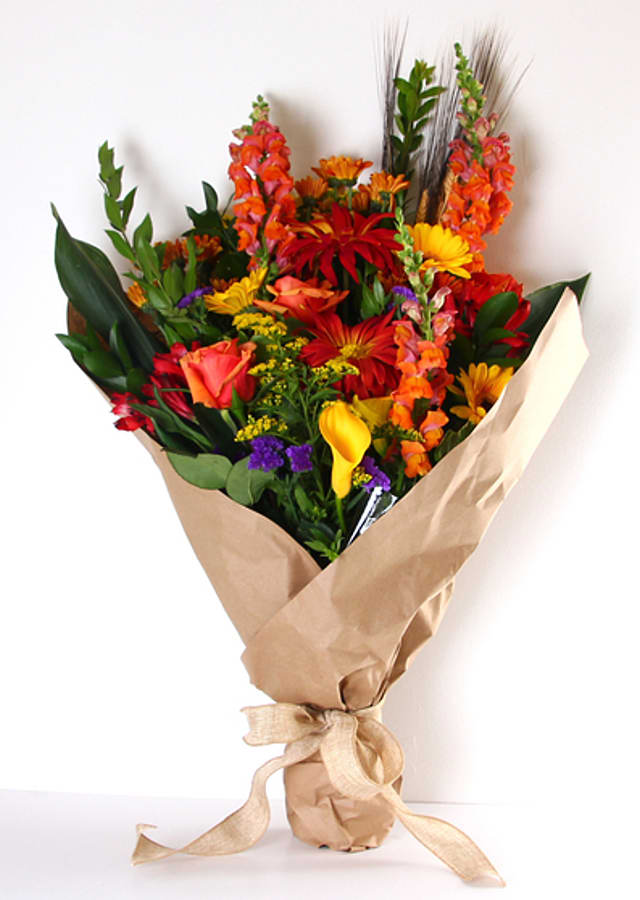 Sunset Sky Wrapped Bouquet - Sunset Sky Wrapped Bouquet includes a mix of bold and bright fresh-cut flowers. Our loose bunches are designed with fresh flowers, individually created by our designers, wrapped, and finished with a lovely bow. Our loose bunches do NOT include vases. Paper and bow color will vary.