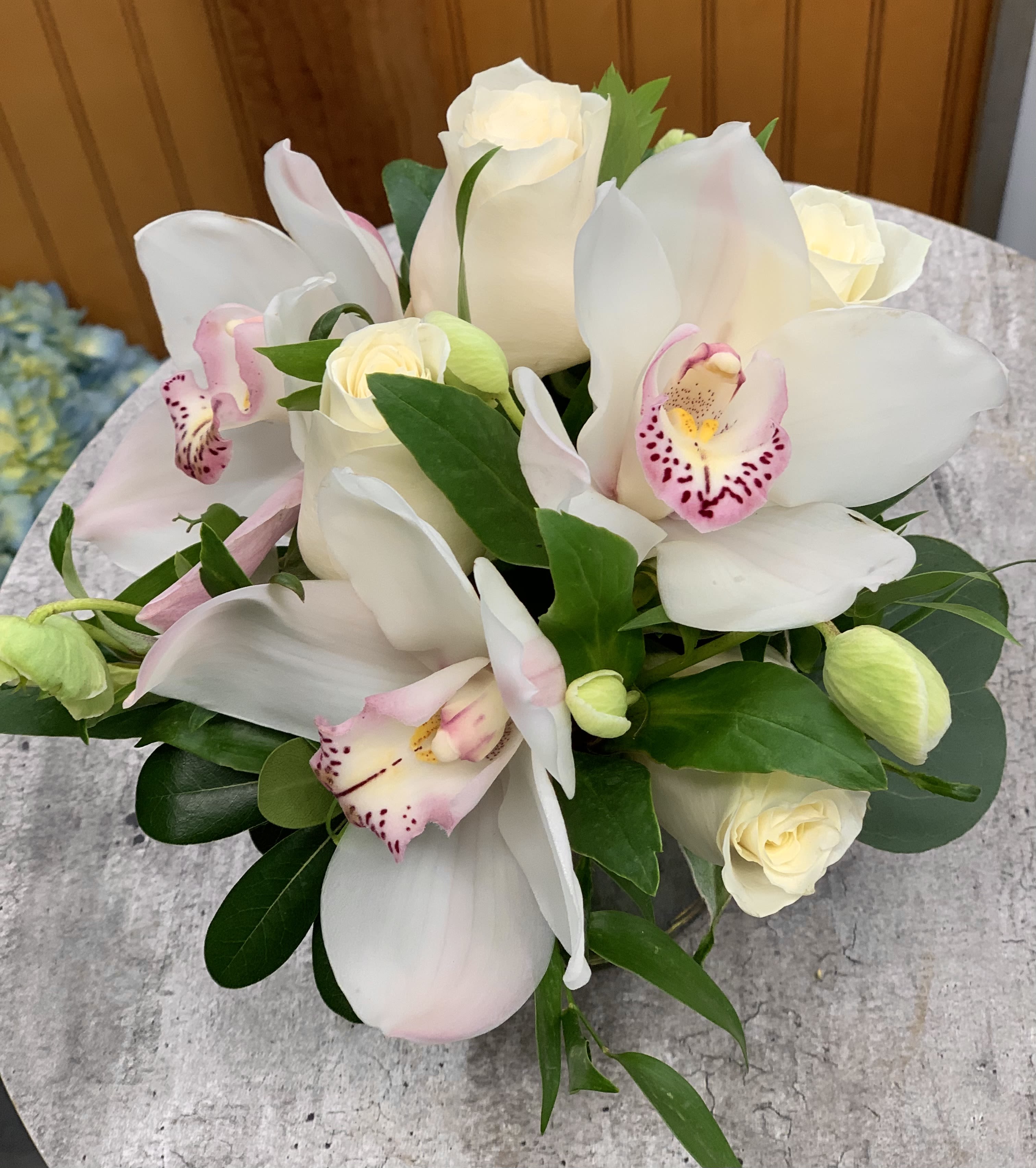 Orchids and roses - For a gift that's both luxurious and lovely, consider a bouquet of exotic fresh white orchids accented with tiny pink blossoms, arranged in a leaf-lined glass cube vase. It's a bit of the tropics, delivered with a smile!   