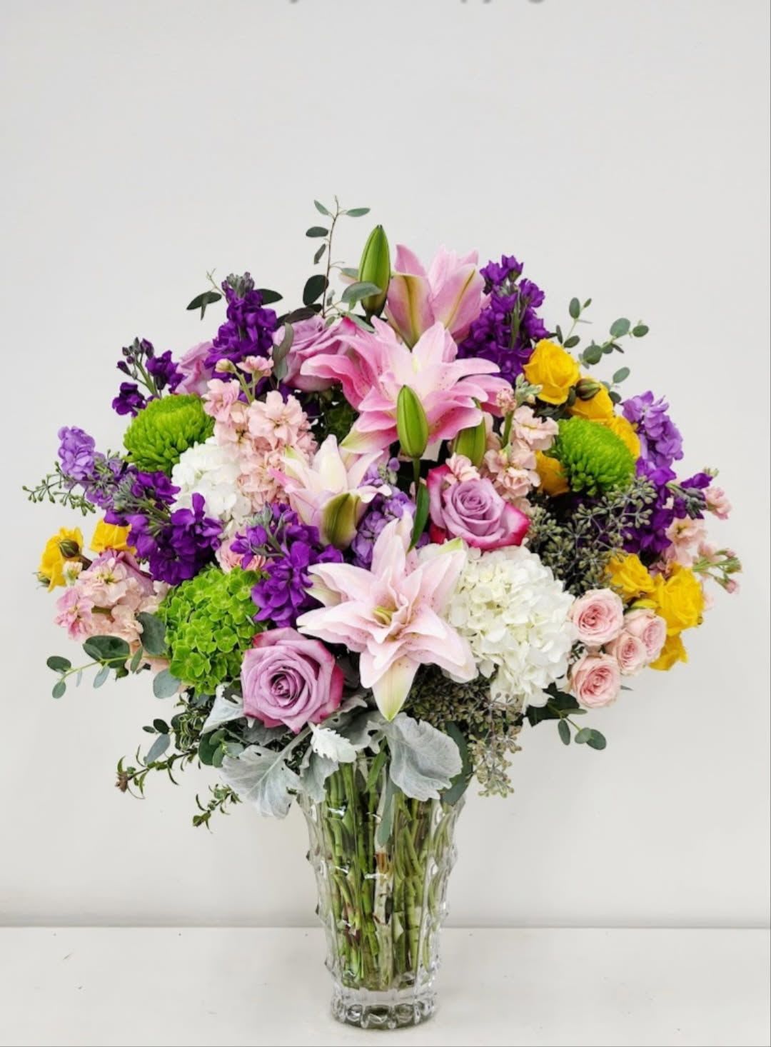 Sweetness of Pastels - Discover serene beauty with Sweetness of Pastels, a thoughtfully composed arrangement of pastel-toned flowers accented with subtle purple and green blooms. This elegant design brings a calming presence to any space, perfect for creating a peaceful atmosphere or gifting someone who appreciates refined, understated luxury. Each stem is carefully selected to harmonize soft hues with natural greenery, resulting in a sophisticated arrangement that whispers rather than shouts.  AS PICTURED: PREMIUM 18&quot; WIDE BY 22&quot; TALL