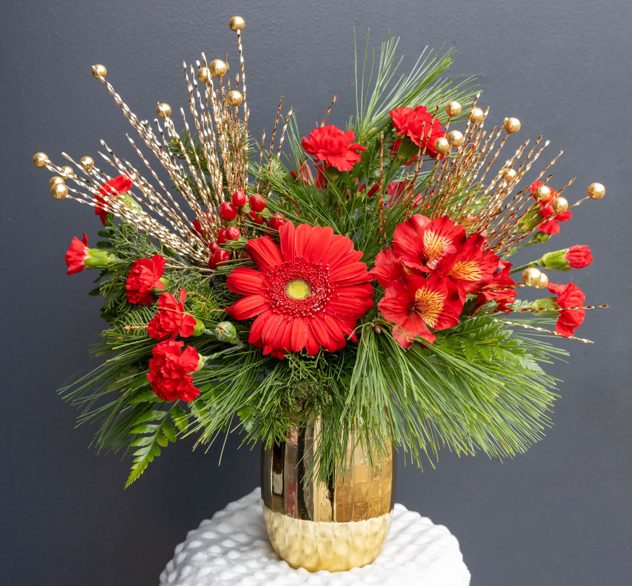 The Great Gatsby - A Dazzling Red &amp; Gold Holiday Arrangement  Step into the glamour of the roaring twenties with The Great Gatsby — a lavish red and gold arrangement that captures the sparkle and sophistication of the season. Featuring radiant Gerbera daisies, rich carnations, and elegant Alstroemeria, this design overflows with classic holiday charm and opulent style.  Perfect for holiday tables, festive gatherings, or as a luxurious gift, this arrangement embodies the magic and celebration of Christmas in full bloom.   Elegant. Timeless. Unforgettable. 