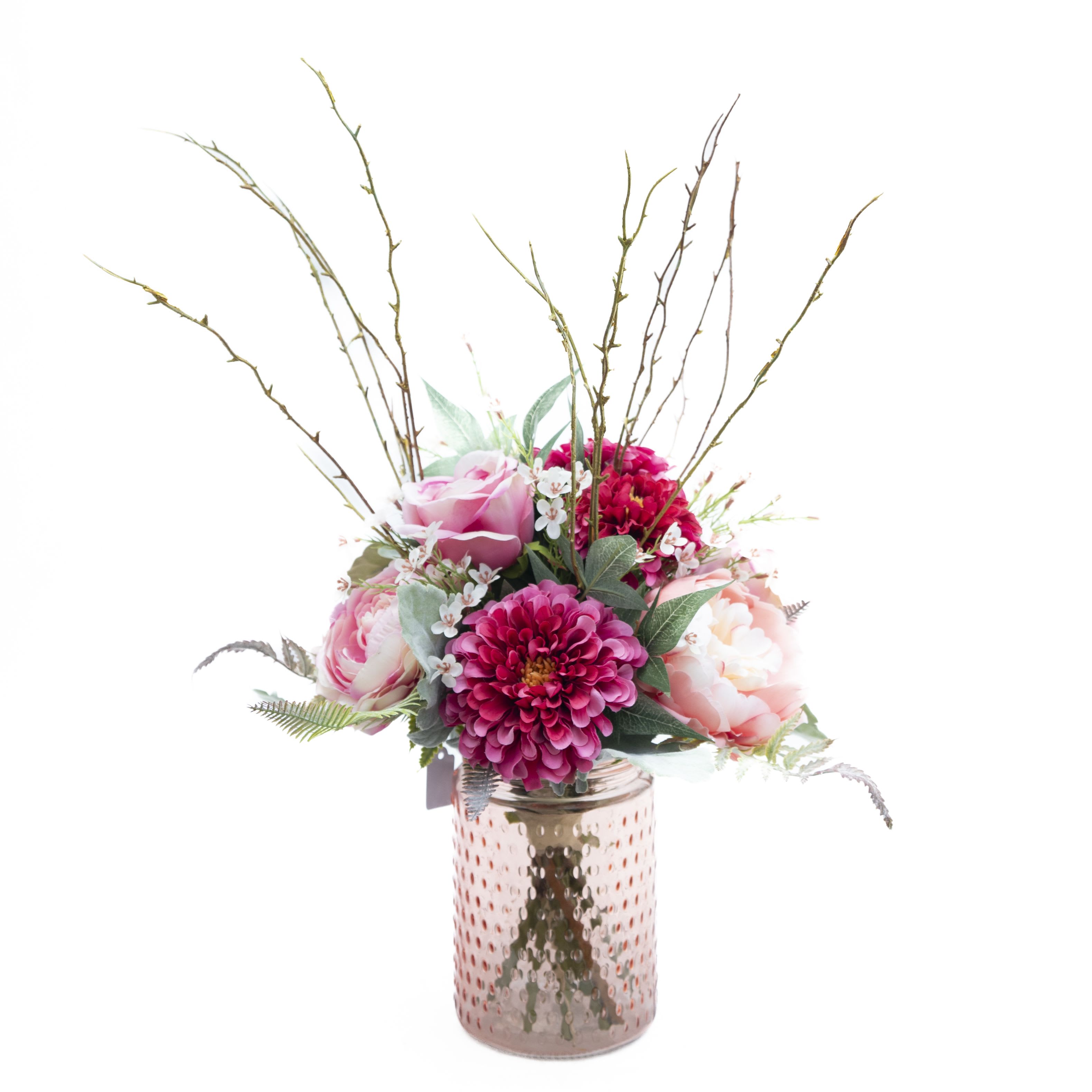 Pink Harmony Bouquet-Artificial - This floral arrangement features a beautiful mix of pink and magenta flowers, including peonies and dahlias, accented with delicate white blossoms and green foliage. The flowers are artfully arranged in a textured, pink glass vase, adding a touch of elegance and sophistication to the display. The tall, slender branches rising above the bouquet give it a dynamic and natural feel, making it perfect for adding a fresh and vibrant touch to any room.