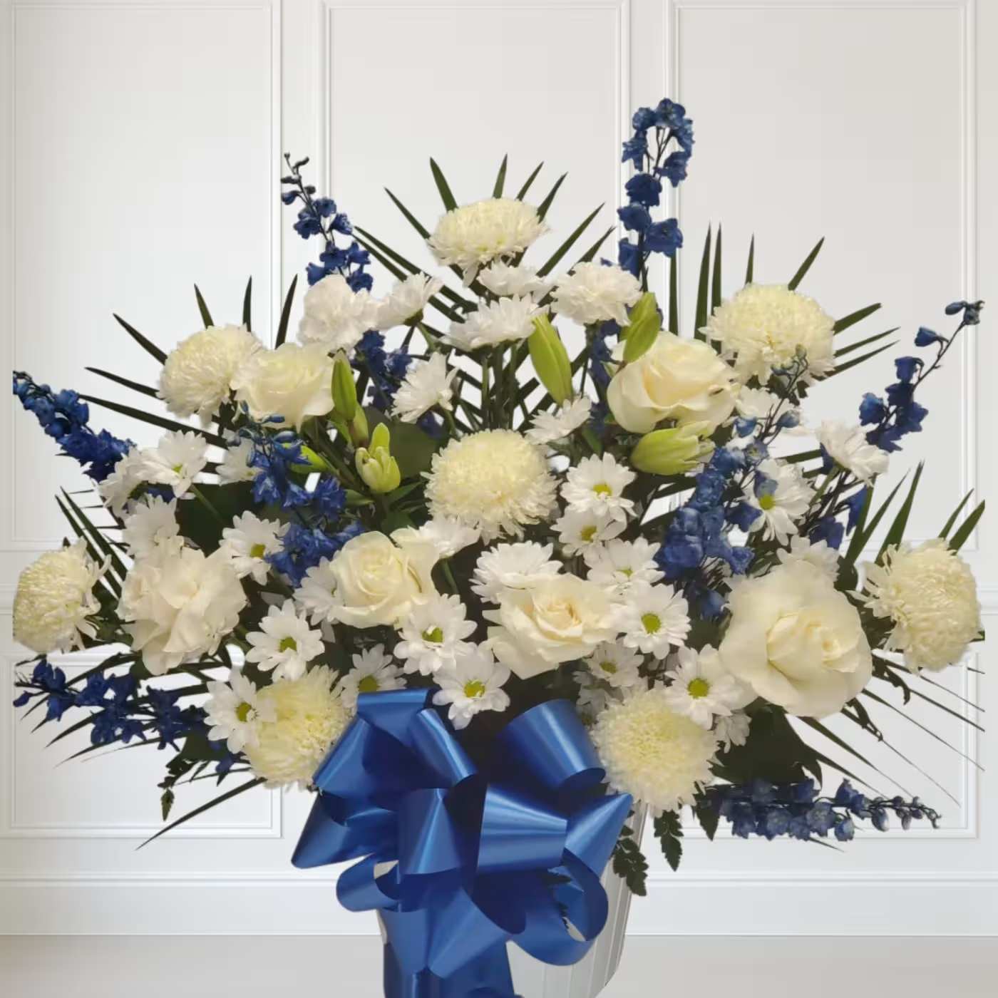 Blue and white floor basket  - This blue and white floor basket includes 8 white mums, 8 blue delphinium, 8 white daisy, 2 white carnations and 2 white lilys  