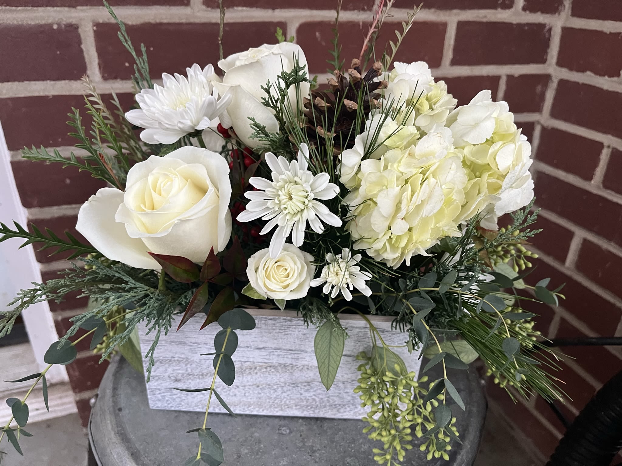 Winter White - Wooden box with all white flowers, a variety of greens and pinecones.   