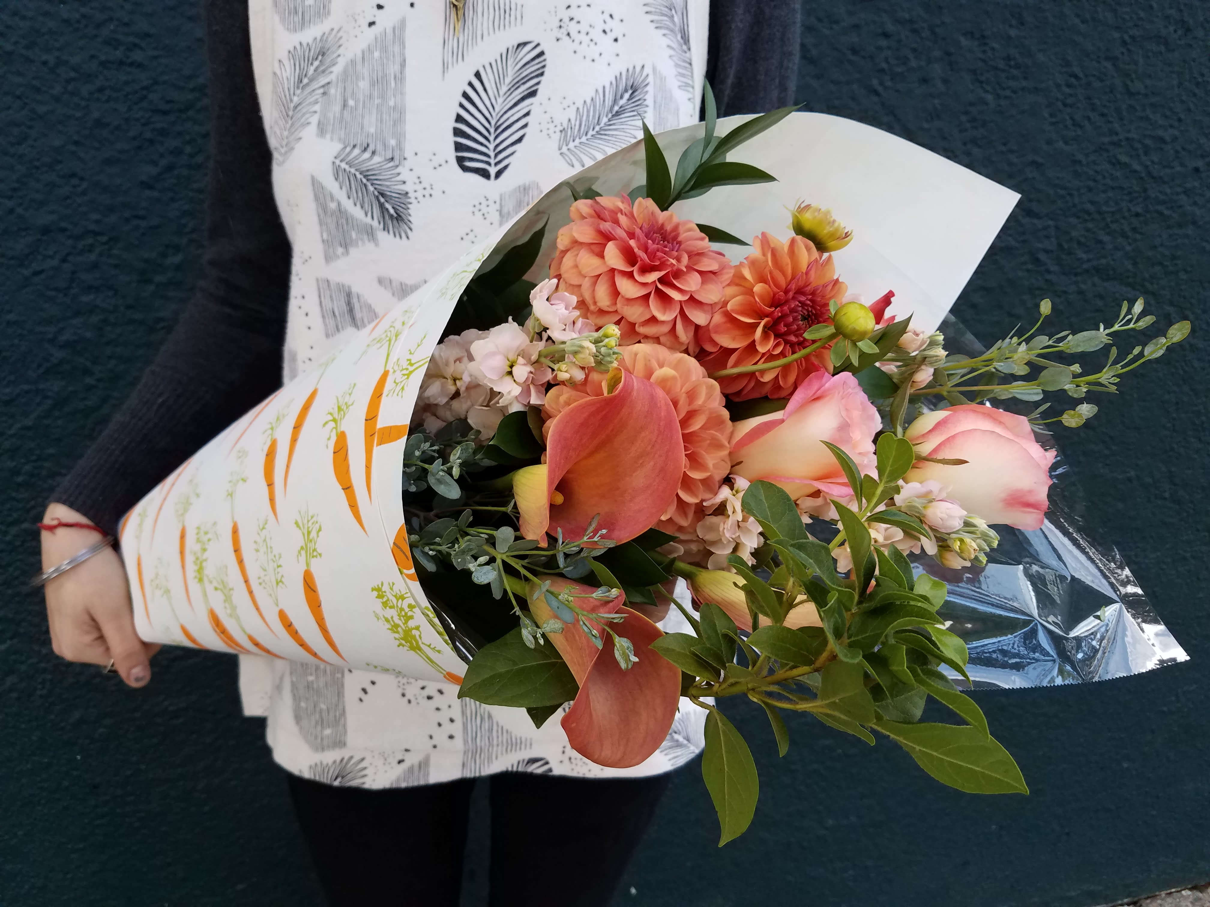 Peach wrap bouquet - The most widely loved color can be all yours! Our peachiest and freshest blooms will be arranged special and wrapped in darling gift paper for anything from your little ballerina's recital to Mom's first day of retirement. Who doesn't love peach?  (Flowers shown are not guaranteed. The designer will make a peach bouquet based on what we have in our inventory. You may not receive that exact pattern but you will receive an equally attractive and fitting paper wrap)