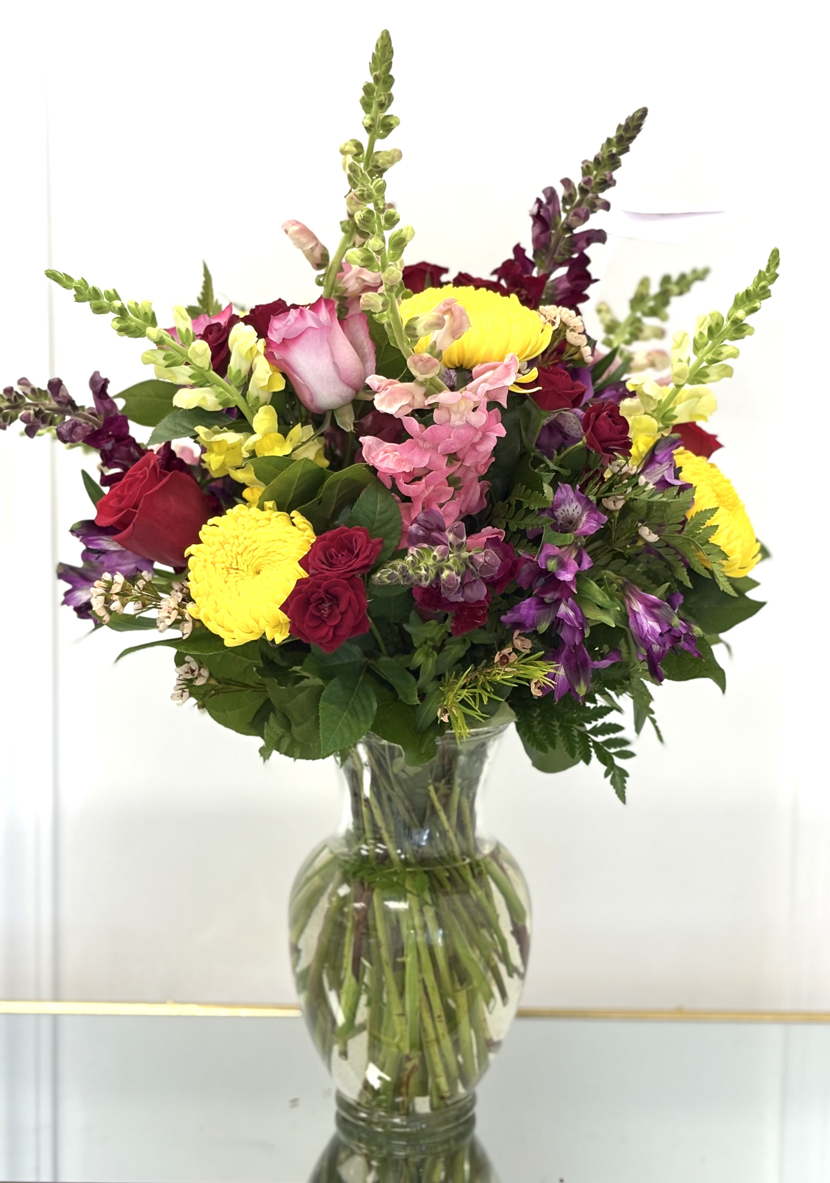 Bright Mix By VLM Flowers - This vase arrangement consists of mixed flowers with bright colors. In the photo, you see the deluxe size.