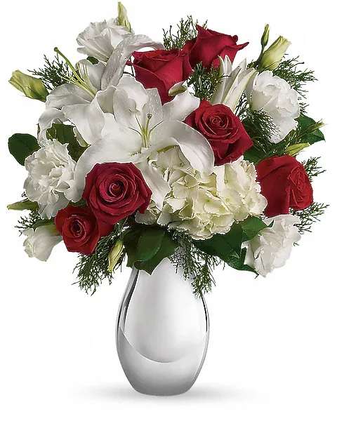 Teleflora's Silver Noel Bouquet - Simple, classic and yet magnificently merry, this festive array of red and white flowers in a silver reflections vase is a gift they'll love - now and forever. The keepsake vase will bring a sparkle to many holidays to come. The lovely Christmas bouquet includes white hydrangea, red roses, white oriental lilies and white lisianthus accented with flat cedar.