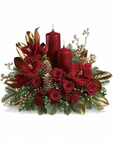 Candlelit Christmas - Christmas by candlelight is the perfect way to delight in the warmth and joy of the season. This elegant arrangement will be at home anywhere in the house, adding grace and beauty to any holiday celebration. Ruby red amaryllis, roses and spray roses are perfectly arranged with golden pinecones and holiday greenery. Two pillar candles in a stunning shade of pomegranate are the perfect touch to light up the night.