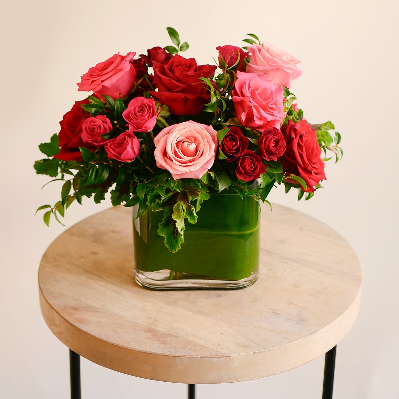 Rosita Garden - This romantic arrangement features a beautiful collection of our premium red and pink roses, accented with mini spray roses and assorted greens in a leaf lined vase. Approximately includes 10 large roses and measures 13 inches tall wide with flowers.