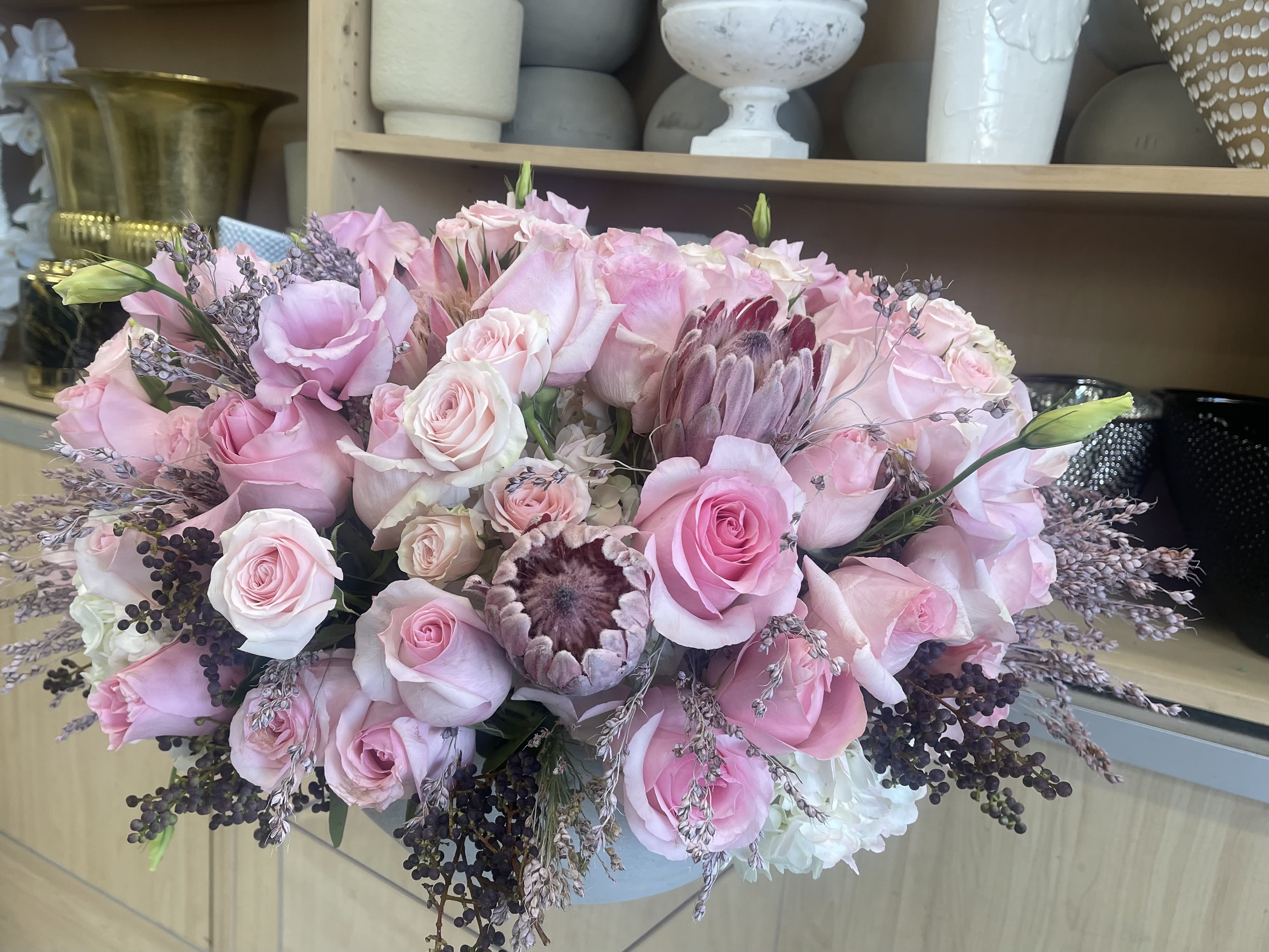 Fancy Party - A romantic mix of soft pink roses, protea, and delicate lisianthus, accented with lavender fillers and berry clusters. Lush and timeless, this arrangement brings gentle charm to any occasion. Romantic, Lush, Modern Classic   Some florals are seasonal, if particular flower will not be available due to season, we will substitute for similar flower, composition, color pallet and value of the arrangements as closely as possible. All effort to create a floral arrangement as close to the photo shown, the actual arrangement may vary slightly in its appearance from the photo shown. If you have any questions about your order, we welcome you to call us in or email   