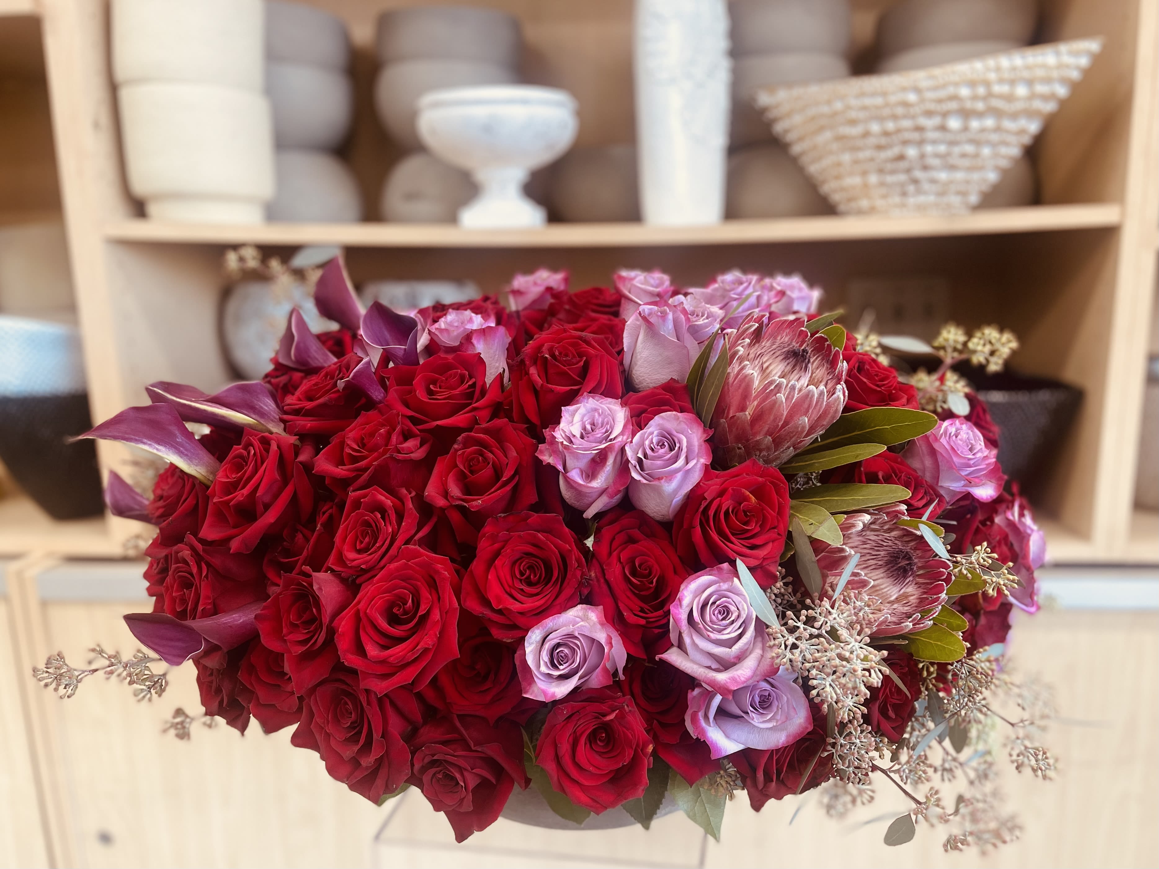 Merry Marigold  - Celebrate the warmth of the season with Mari Marigold, a stunning blend of golden marigolds, crimson roses, and fresh winter greenery. This radiant arrangement captures the perfect balance between holiday elegance and cheerful charm. Perfect as a holiday centerpiece, a heartfelt gift, or a bright accent for winter décor, Mari Marigold embodies warmth, joy, and timeless beauty.   Some florals are seasonal, if particular flower will not be available due to season, we will substitute for similar flower, composition, color pallet and value of the arrangements as closely as possible. All effort to create a floral arrangement as close to the photo shown, the actual arrangement may vary slightly in its appearance from the photo shown. If you have any questions about your order, we welcome you to call us in or email   