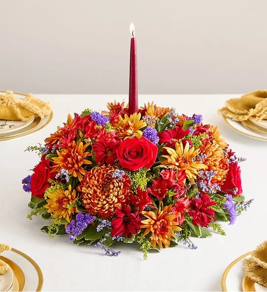 Brilliant Autumn centerpiece - Our centerpiece captures the rich beauty of autumn, with bursts of red, bronze, and purple amid assorted greenery. A burgundy taper candle stands at the center, ensuring a warm and welcoming ambience for every gathering.