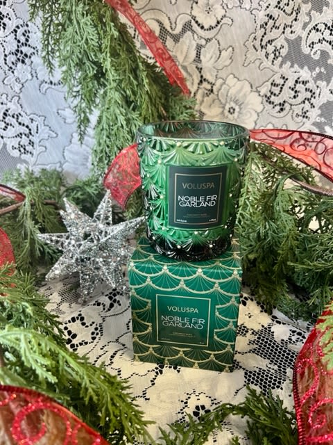 Noble Fir Garland Voluspa Candle - Voluspa's unique coconut wax blend is housed in a 6.5 oz. holiday inspired embossed glass with a tapered silhouette decorative gift box. The single wick allows you to enjoy fragrance throw for 40 hours.