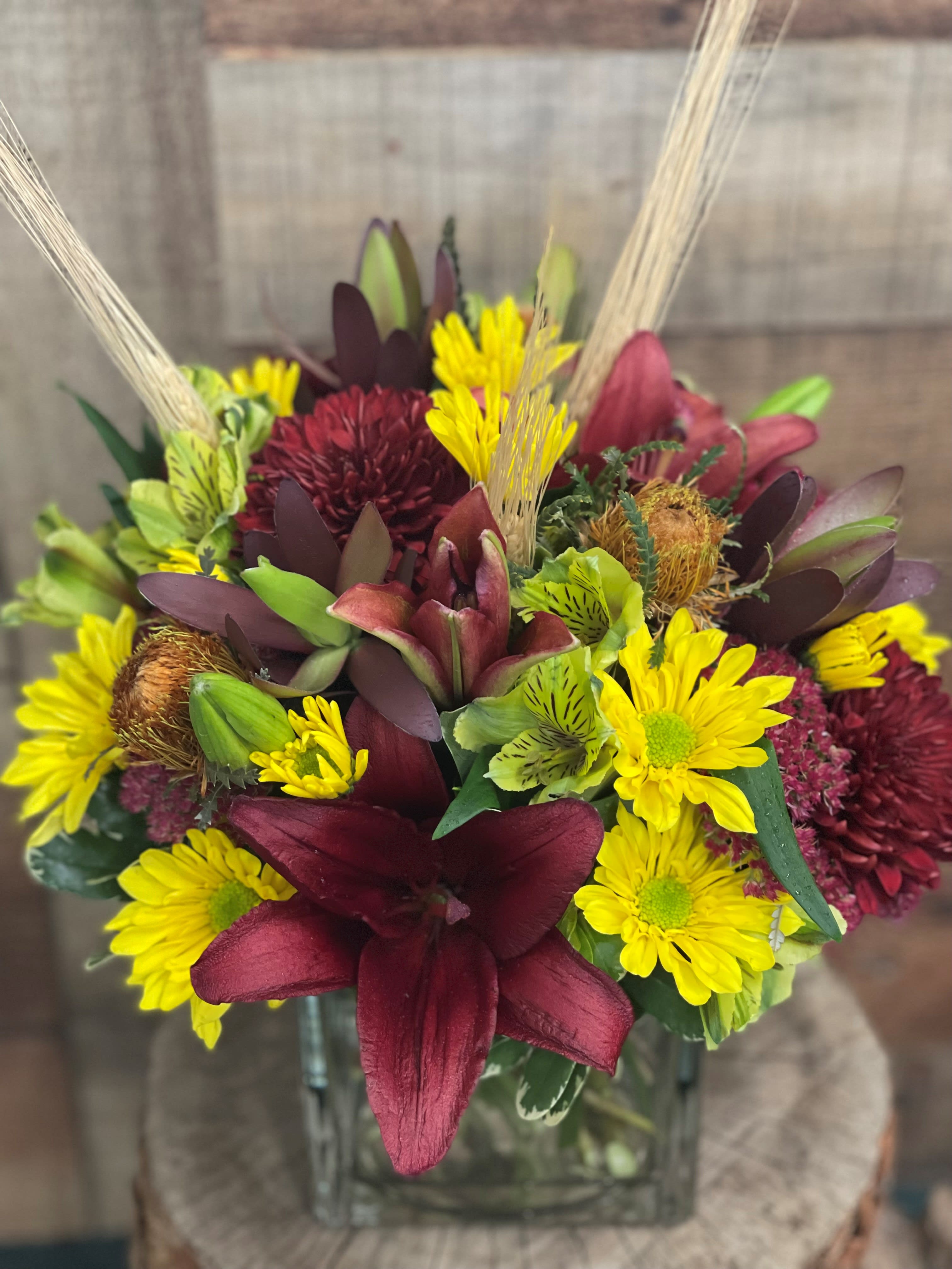 Autumn Treasures - This rich display of fall colors is w great mix of deep color lilies and burgundy mums accented with other long lasting flowers.