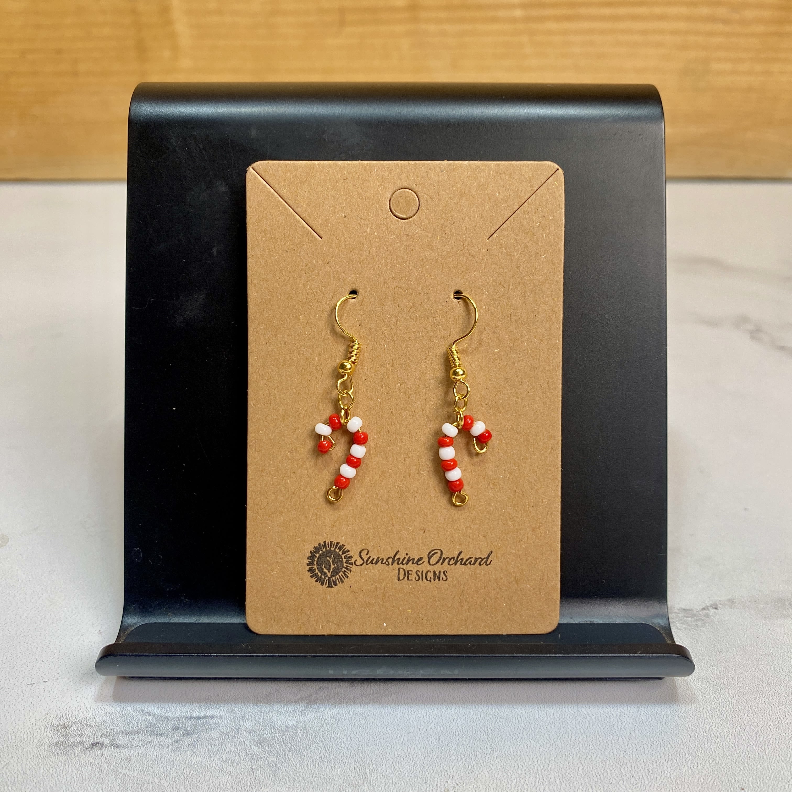 Beaded Candy Cane Earrings - Our Beaded Candy Cane Earrings let you have a bit of holiday magic on you wherever you go! Made of acrylic beads and gold plated findings, these little earrings are sure to bring a smile to anyone that sees them! Earrings are handmade by Sunshine Orchard Designs