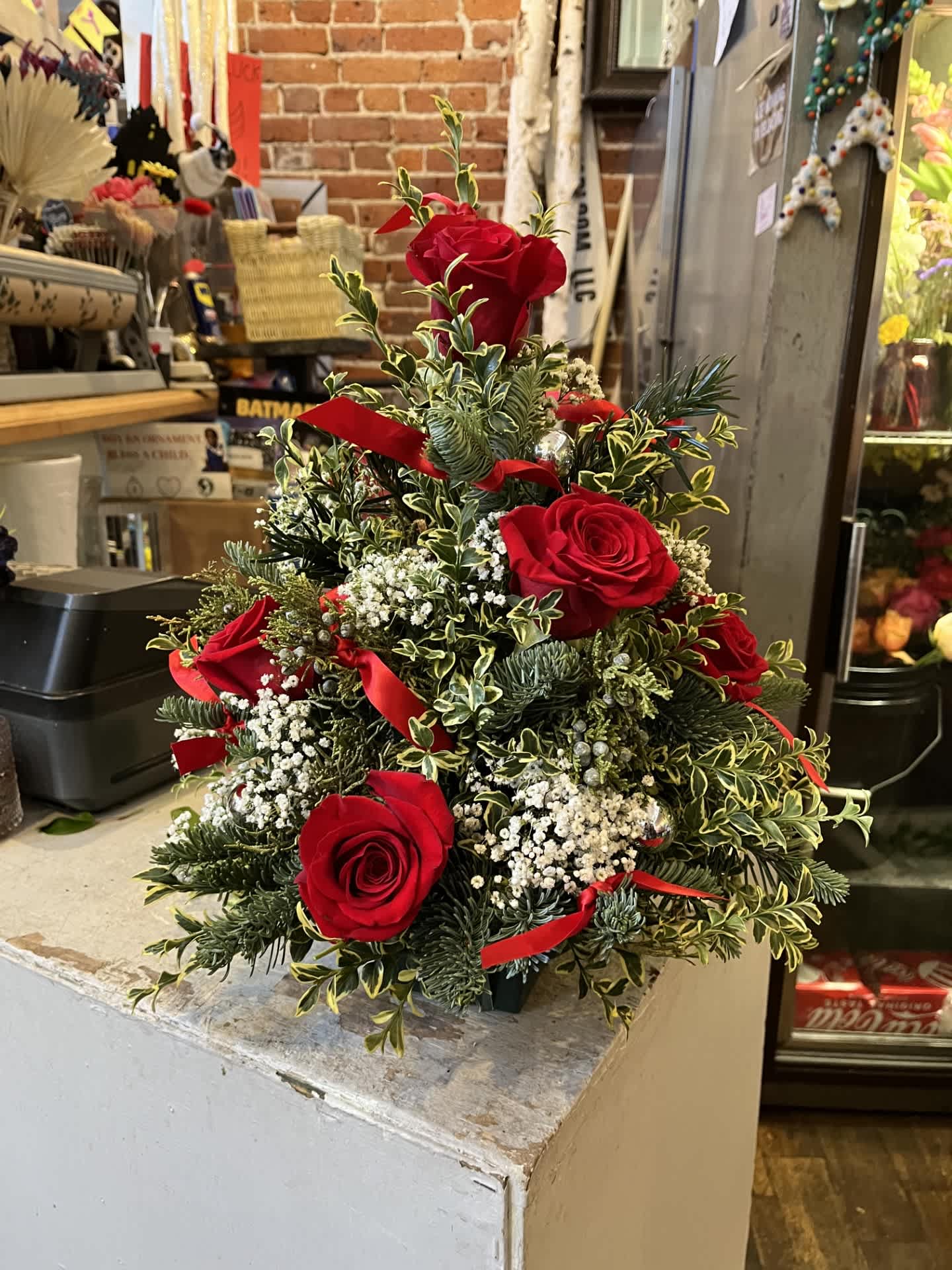 My Little Christmas Tree - Holiday Greens with roses and baby's breath, bell ornaments and ribbon.  Assembled to give a little Christmas to that someone special. Same day delivery if order before noon MST.