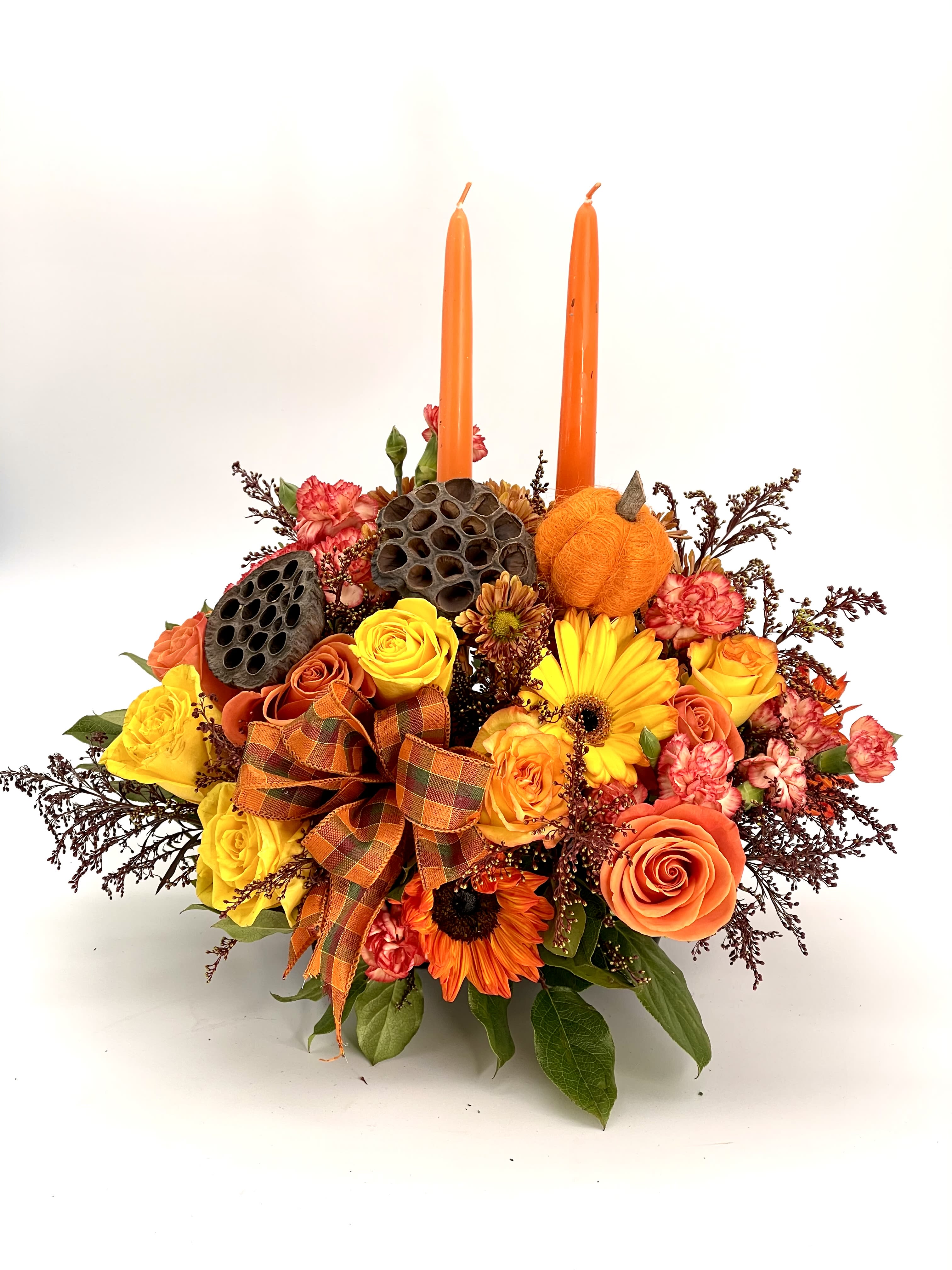 Autumn Glow - Bring the warmth of the season to your table, featuring Yellow and Orange Roses, Gerbera Daisies and rustic fall accents with two taper candles and a ribbon.