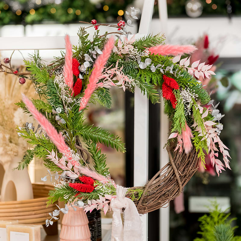 Forever Mini Holiday Wreath - Decorate your home with this beautiful Forever Holiday Mini Wreath. Arranged with mixed evergreen foliage such as spruce, fir, and pine, and pops of unique dried flowers, this wreath is long lasting, full of texture and style in shades of bright red, whites, silver &amp; pink hues.  Blush Chiffon Silk Ribbon to accent. (12&quot;)  This unique mini wreath will look perfect in your entryway or decorate an interior wall for a wintry holiday vibe.  