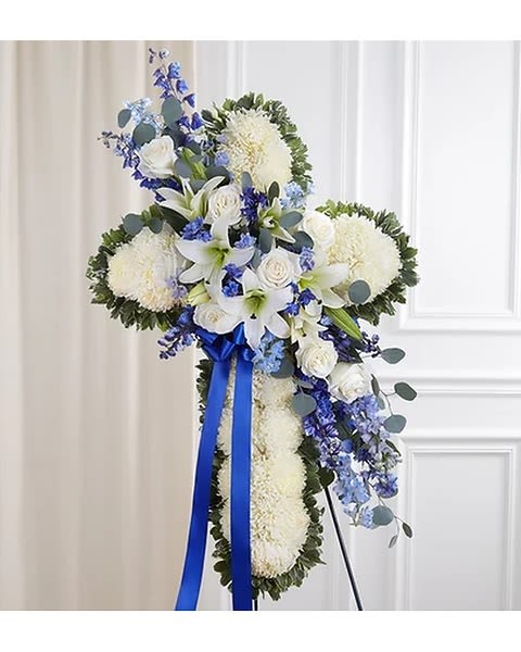 Sending Prayers Blue &amp; White Standing Cross - Celebrate a life of faith and devotion with our elegant sympathy arrangement. A bed of pristine white blooms is crafted into the shape of a cross by our caring florists. Flourishes of white and blue flowers cascade down the center. What a beautiful tribute to honor a loved one, while providing peace and comfort when itâs most needed. Standing cross arrangement with white football mums, roses and Oriental lilies; blue delphinium; accented with silver dollar eucalyptus, assorted greenery and blue ribbon Appropriate for the funeral home Our florists hand-design each arrangements, so colors and varieties may vary based on local availability