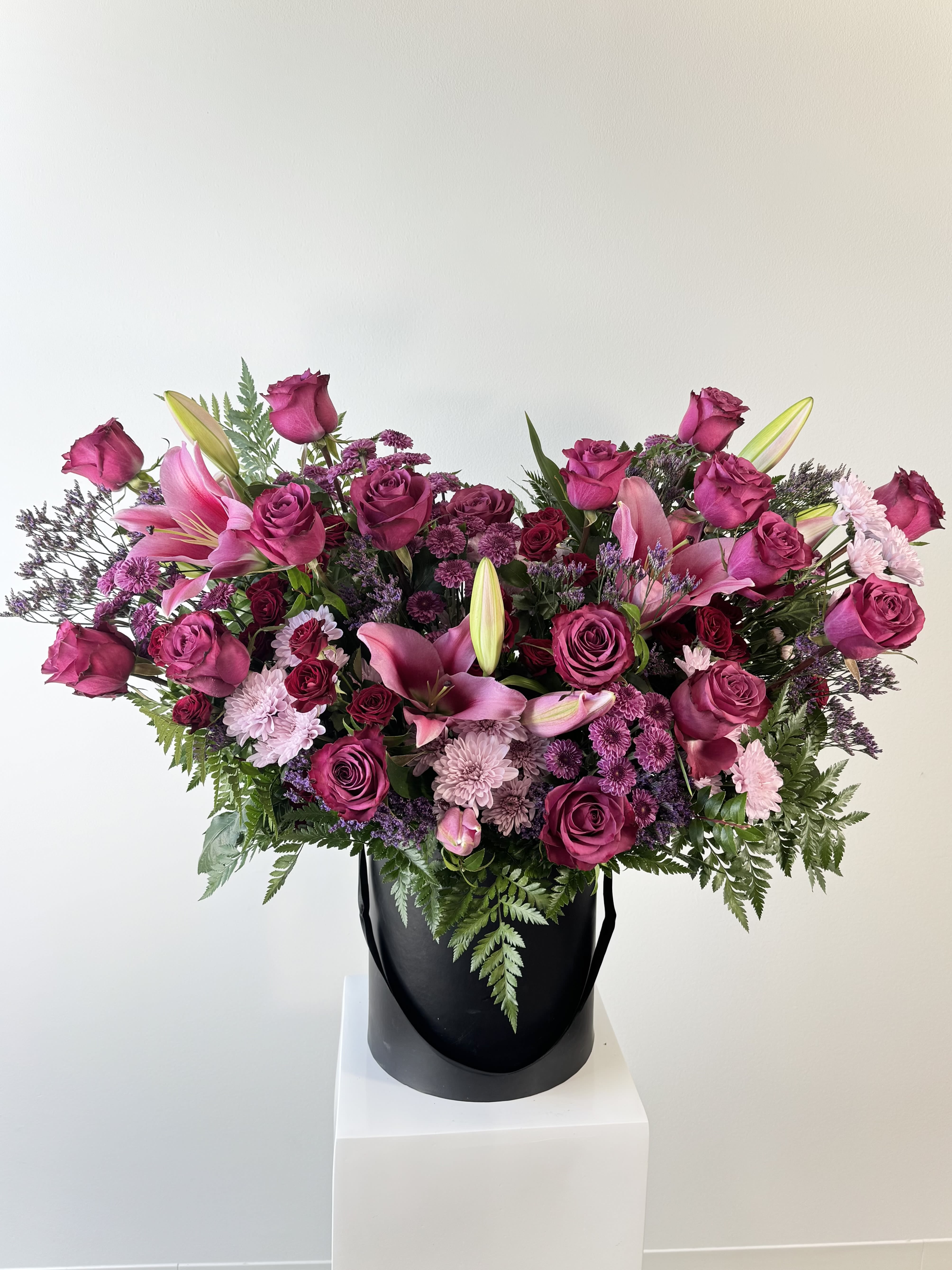 Power of Love - Power of Love Flower Arrangement – Luxe Pink Lily &amp; Purple Rose Box Bouquet Unleash romance with the Power of Love, our grandest statement piece! This opulent cylindrical box overflows with fragrant pink lilies, regal purple roses, bold purple &amp; pink chrysanthemums, and fiery red spray roses. Towering, lush, and unforgettable, it’s designed to command attention and capture hearts.  Why Power of Love Dominates: Pink Lilies: Show-stopping blooms radiate grace, devotion, and prosperity. Purple Roses: Rare symbols of enchantment, majesty, and love at first sight. Purple Chrysanthemums: Rich, full petals signify loyalty and deep passion. Pink Chrysanthemums: Soft, voluminous layers express joy and admiration. Red Spray Roses: Clusters of miniature hearts ignite fiery romance.  Hand-arranged in a premium matte cylindrical box with protective hydration. One of our largest designs—perfect for anniversaries, proposals, Valentine’s, milestone birthdays, or “I’m all in” declarations.  Power of love flower box, large pink lily bouquet, purple rose chrysanthemum arrangement, red spray rose gift box, luxury cylindrical flower box, grand anniversary flowers, Valentine’s Day big bouquet, proposal floral statement, same-day luxury flower delivery, oversized romantic roses. Make them speechless and order Power of Love today. Same day delivery available. Power of love, luxury flower box, pink lilies. purple roses, grand bouquet