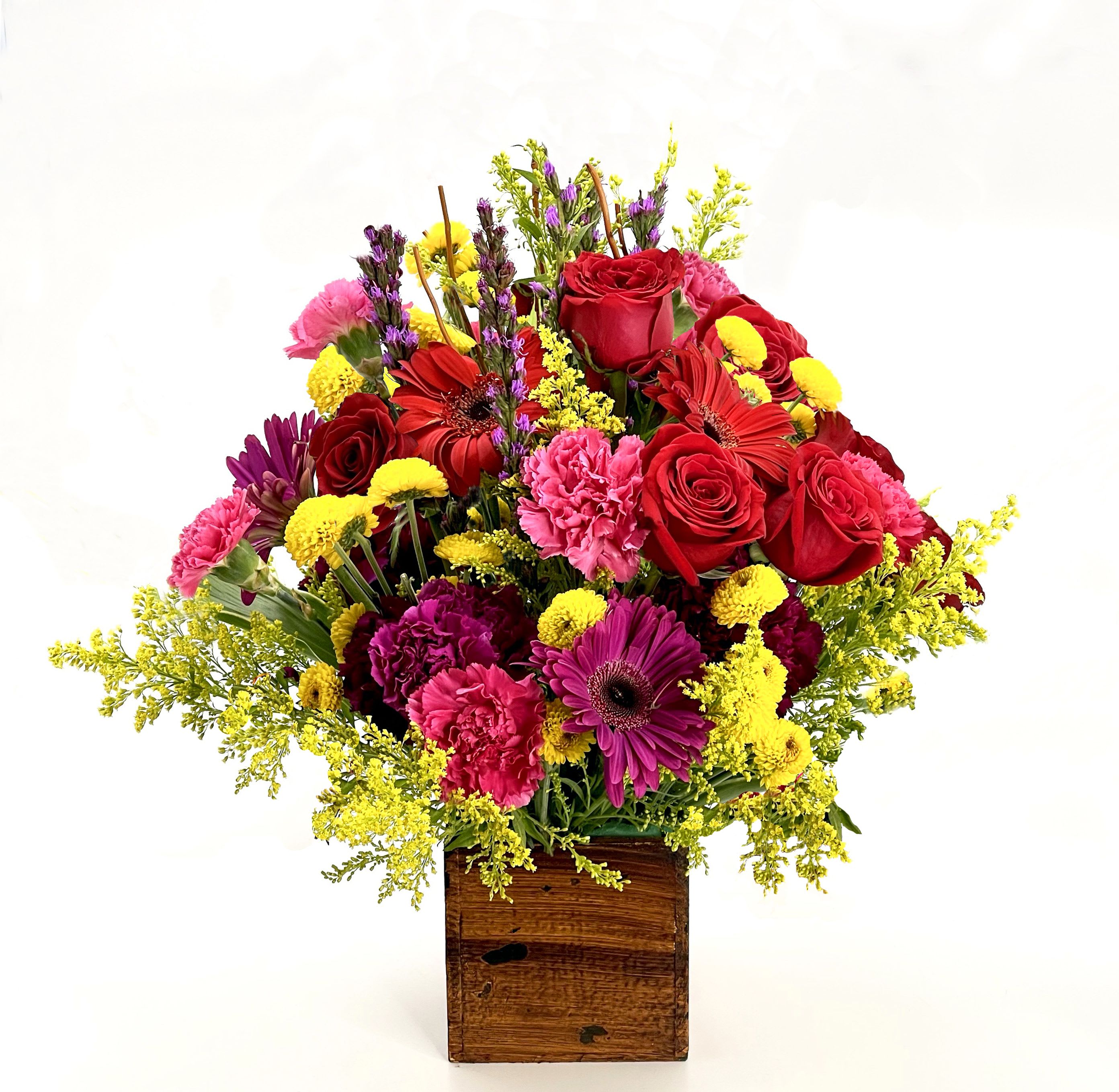 Summer Meadow - A bright and cheerful arrangement featuring red roses, pink carnations, purple gerberas, and yellow blooms in a rustic wooden box. Perfect for adding vibrant color and joy to any room or celebration.