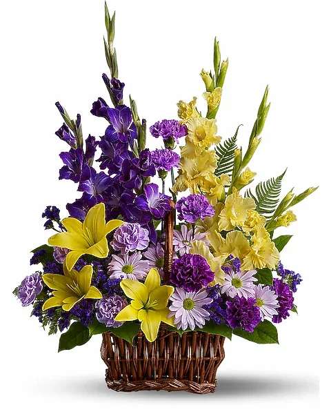 Basket of Memories - Honor rich remembrances of one dearly missed with a vivid mix of blooms that offer strength and comfort alike during a time of sorrow. Beautiful fresh flowers such as yellow asiatic lilies and gladioli contrast with purple carnations, statice and gladioli, plus lavender carnations and chrysanthemums in a rectangular basket with handle.