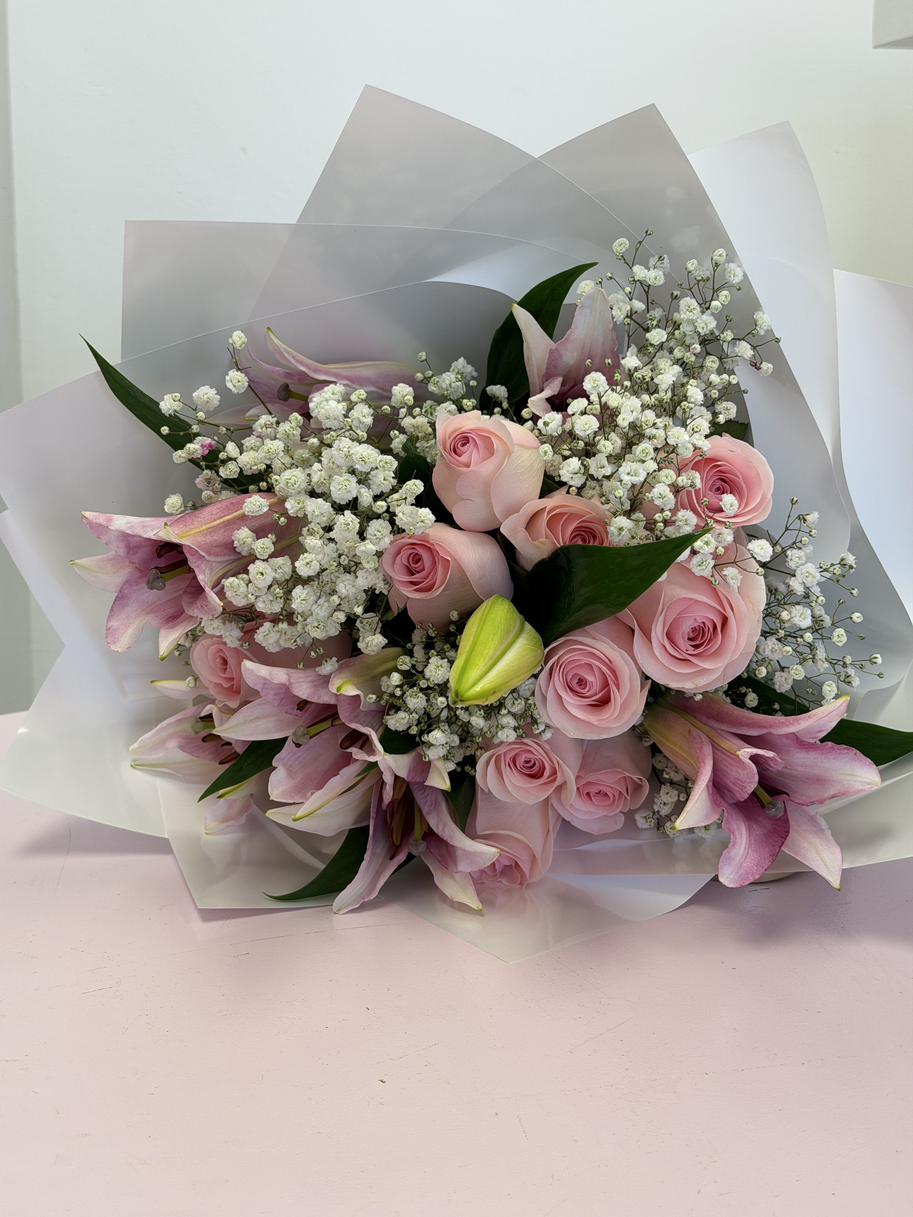 Sweet Lily &amp; Rose Bouquet  - Soft, sweet, and romantic. Our bouquet of 12 light pink roses and pink lilies, accented with Baby’s Breath, is beautifully wrapped in white floral paper for a clean and elegant look. Perfect for anniversaries, birthdays, or simply to show someone you care. A delicate and stylish design—crafted with love by Magenta Floral. 