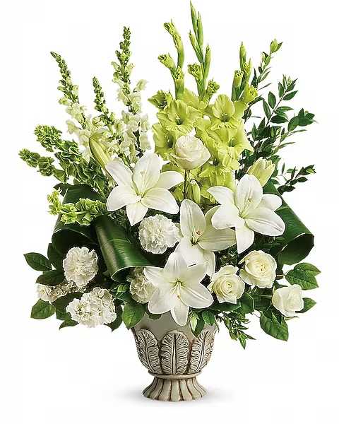Teleflora's Clouds Of Heaven Bouquet - Peaceful and majestic in a large antiqued pot, this wondrous white arrangement is a touching tribute to a bright life, and your unending support. White roses, white asiatic lilies, green gladioli, white carnations, bells of ireland, white snapdragons, and white stock are accented with myrtle, green ti leaves, and lemon leaf. Delivered in a Thoughtful Tribute pot.