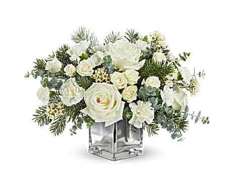 Teleflora's Arctic Blooms Bouquet - Teleflora's Arctic Blooms Bouquet captures winter's serene beauty with snowy white roses, soft winter greens, and seasonal accents in a chic silver cube. A stunning Christmas or winter gift to brighten the season. Teleflora's Arctic Blooms Bouquet includes white roses, white spray roses, white carnations, white miniature carnations, white waxflower, spiral eucalyptus, and noble fir in a silver glass cube Orientation: All-Around
