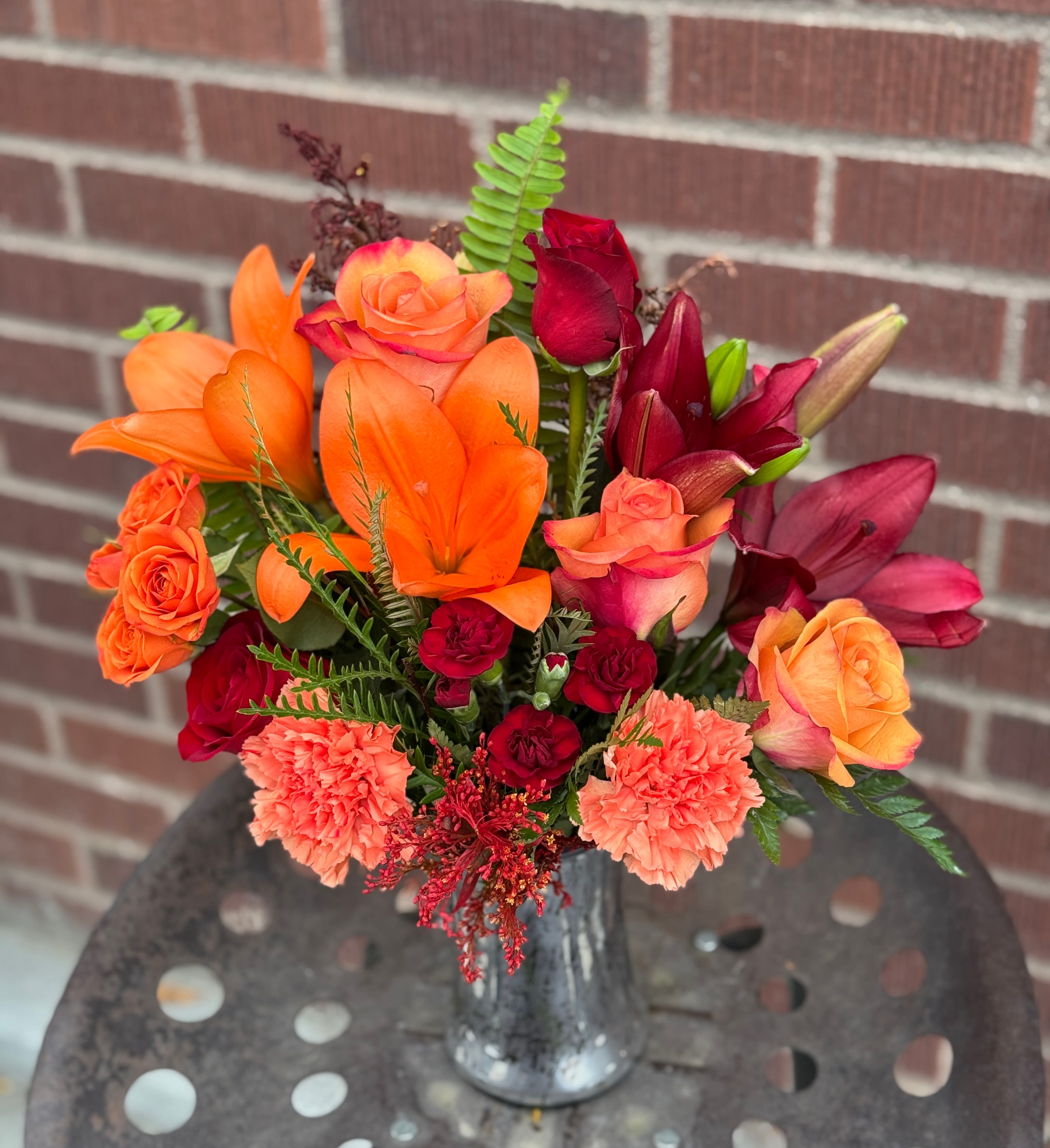 Fall Blush - This fall, make that special someone blush with joy! Gorgeous bi-color roses and lilies brighten their day, while the magnificent mercury glass hurricane vase is a sparkling gift they'll always cherish.