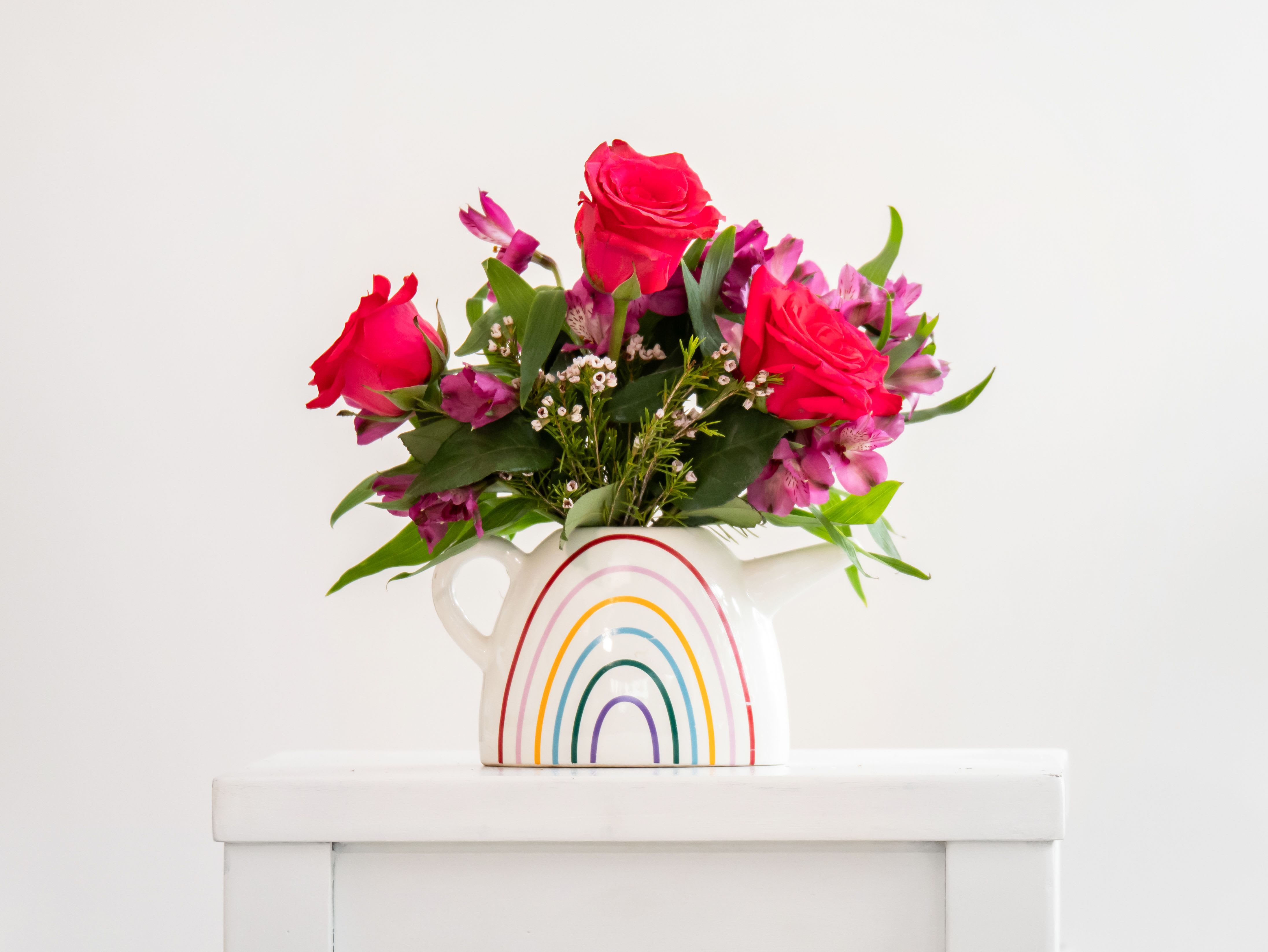 Just Because by Dixie's Flowers - “Bright and joyful! This rainbow vase overflows with vibrant red roses and playful pink blooms—perfect for sending cheer and a splash of color to any day.” 