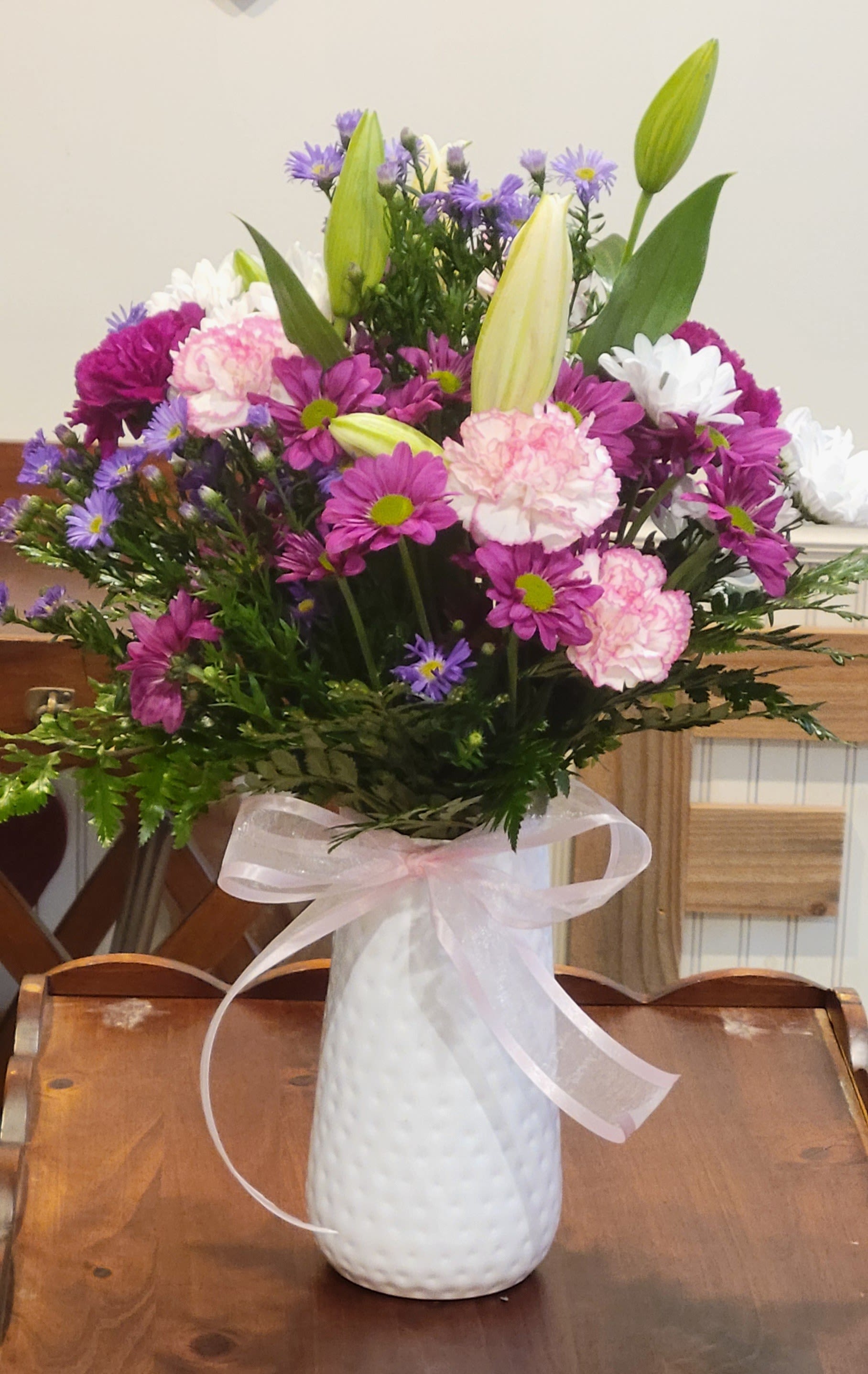 Dixie's Favorite by Dixie's Flowers - “A cheerful arrangement featuring soft pink roses, white lilies, and playful daisies, accented with fresh greenery. This bright and uplifting bouquet is designed to bring joy, whether you’re celebrating a special occasion or simply adding a touch of beauty to the day.”