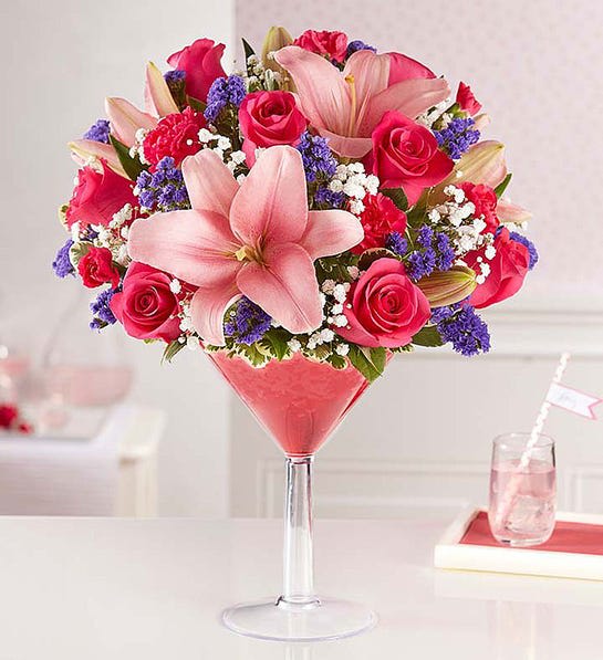 Girls’ Night Out - What’s more fun than sipping cocktails with all your favorite girls? How about surprising them with a chic and totally unique new floral creation! Exclusively from our Happy Hour collection, this signature bouquet is served up with a fun, feminine mix of hot pink and purple blooms inside a martini to celebrate good friends, family or any fabulous woman you know in truly original style!  Our florists hand-design each arrangement, so colors and varieties may vary due to local availability All-around arrangement of hot pink roses and mini carnations, light pink Asiatic lilies and purple statice; accented with baby’s breath and variegated pittosporum To ensure lasting beauty, lilies may arrive in bud form, and will fully bloom over the next few days Artistically designed in martini glass with ruby red crystal gel