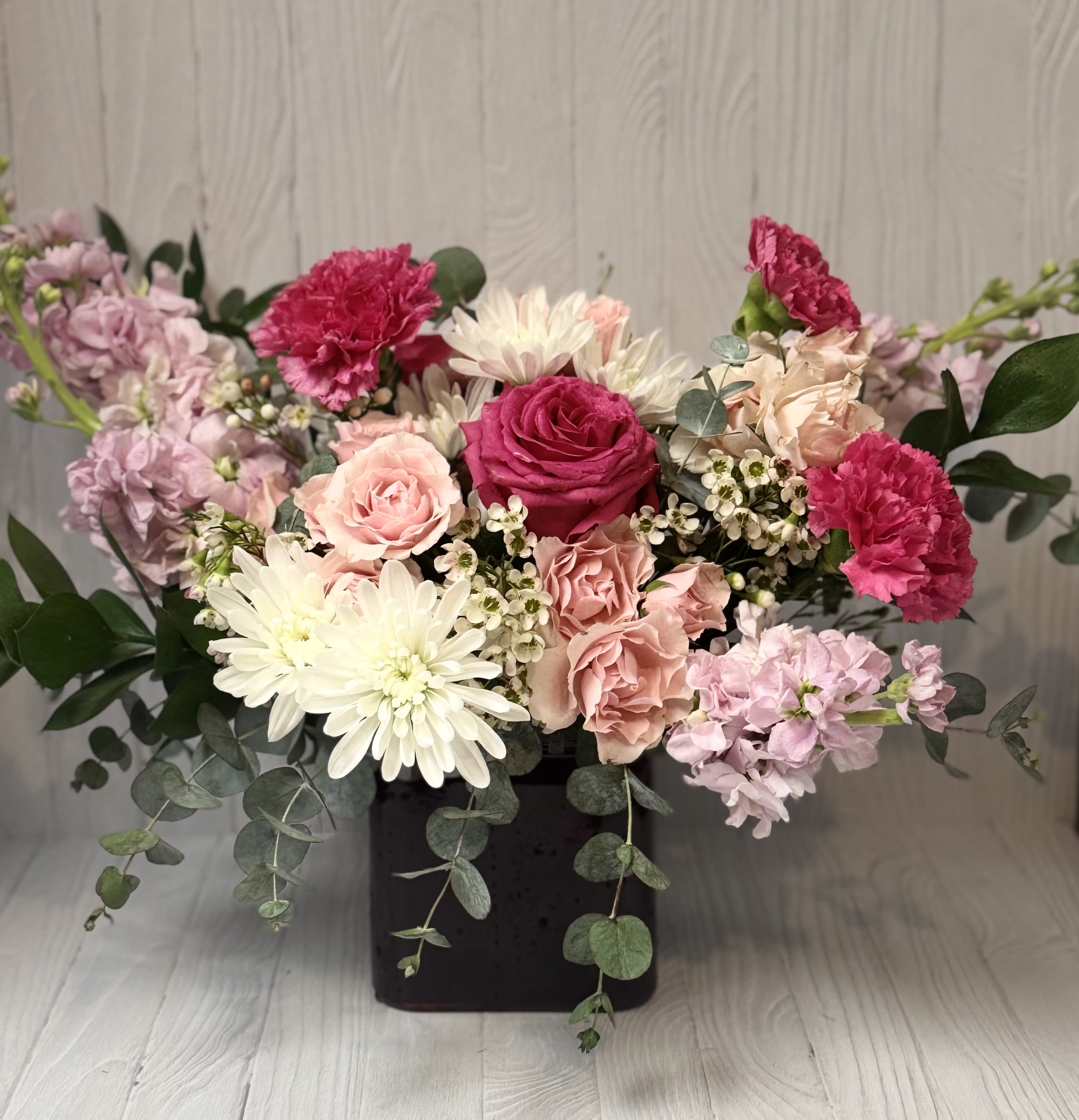 Abundance Cube - Beautiful flowers to cheer up your loved one in a square, modern vase!  Includes Roses, Spray Roses, Carnations, Sweet smelling Stock and Daisies with premium Filler and Greenery for a delightful pick-me-up!