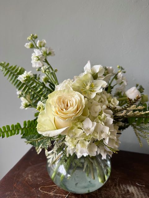 Simply Elegant - This beautiful floral arrangement is a naturally perfect way to tell someone you're thinking of them! The simple elegance of the white florals against our diverse collection of greenery make this perfect for any occasion, whether it be romance, sympathy or just because.