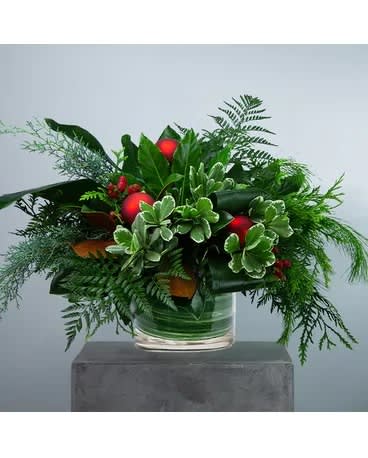 Abundant Joy - Spread joy. Abundant Joy steps up for a natural pick me up. Featuring an abundance of mixed foliage like magnolia, aroma pine, arborvitae, pittosporum, leather leaf, and aspidistra designed in a clear glass cylinder container. Approximately 30&quot; W X 19&quot; H  DGTMF-1250