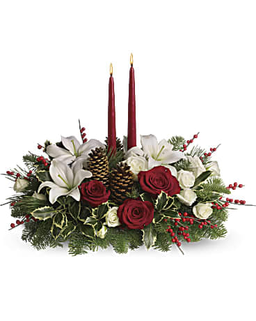 Christmas Wishes Centerpiece - Your wishes for a classic Christmas centerpiece have come true! This elegant arrangement features two glowing red taper candles atop a bed of noble fir, white pine and luxurious roses. Red and white roses are mixed with festive noble fir, white pine and variegated holly beneath two red taper candles. Red berries and pine cones add to the Christmas fun. Orientation: All-Around DG127-1B