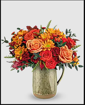 Magestic Meadow - Embrace the charm of autumn's majestic meadow with this heartfelt rose bouquet, presented in a stunning stoneware pitcher with a captivating reactive glaze. This versatile piece is not only a beautiful centerpiece but also food-safe, making it ideal for decorating your table on Thanksgiving or any memorable occasion. Teleflora's Majestic Meadow Bouquet features vibrant orange roses, spray roses, miniature maroon carnations, rustic brown button spray chrysanthemums, and bronze daisy spray chrysanthemums, accented with parvifolia eucalyptus and grevillea. Presented in Teleflora's Majestic Meadow Pitcher, capturing autumn's rich hues and natural beauty. Orientation: All-Around 