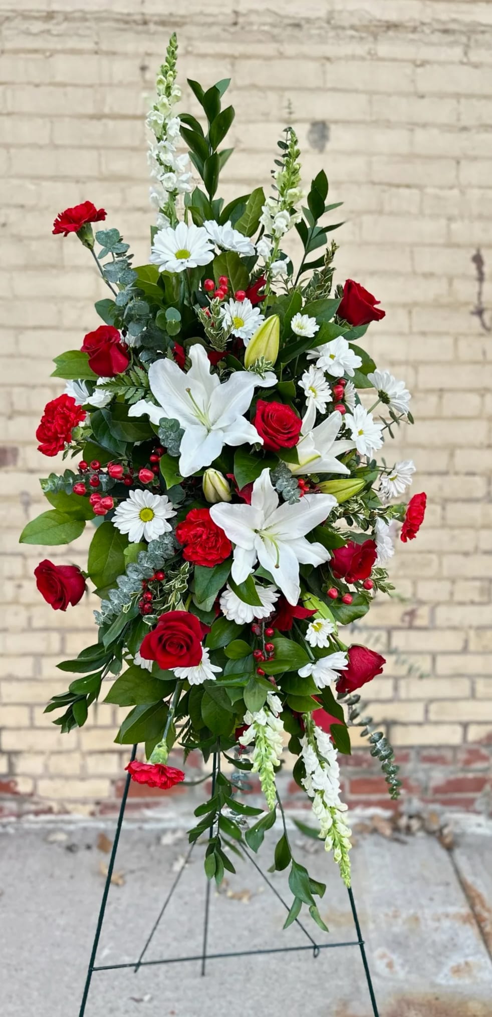 Red &amp; White Tranquility Easel Spray  - A dramatic contrast of brilliant red and tranquil white flowers expresses the range of emotions coloring the memorial experience, offering consolation and hope for the future to loved ones, family and friends. A grand display with a beautiful assortment of fresh blooms. This display is created on an easel for that grand appearance.   Approximate Dimensions: 65"H 35"W